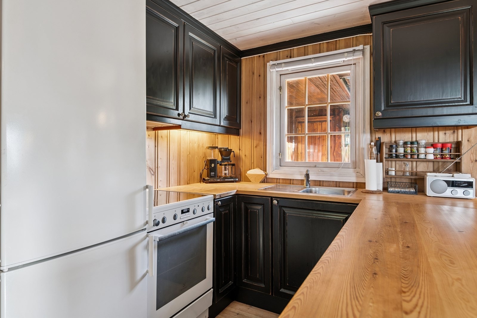 Innredning med aldringsmalte, profilerte dører og heltre benkeplate. Galleribilde