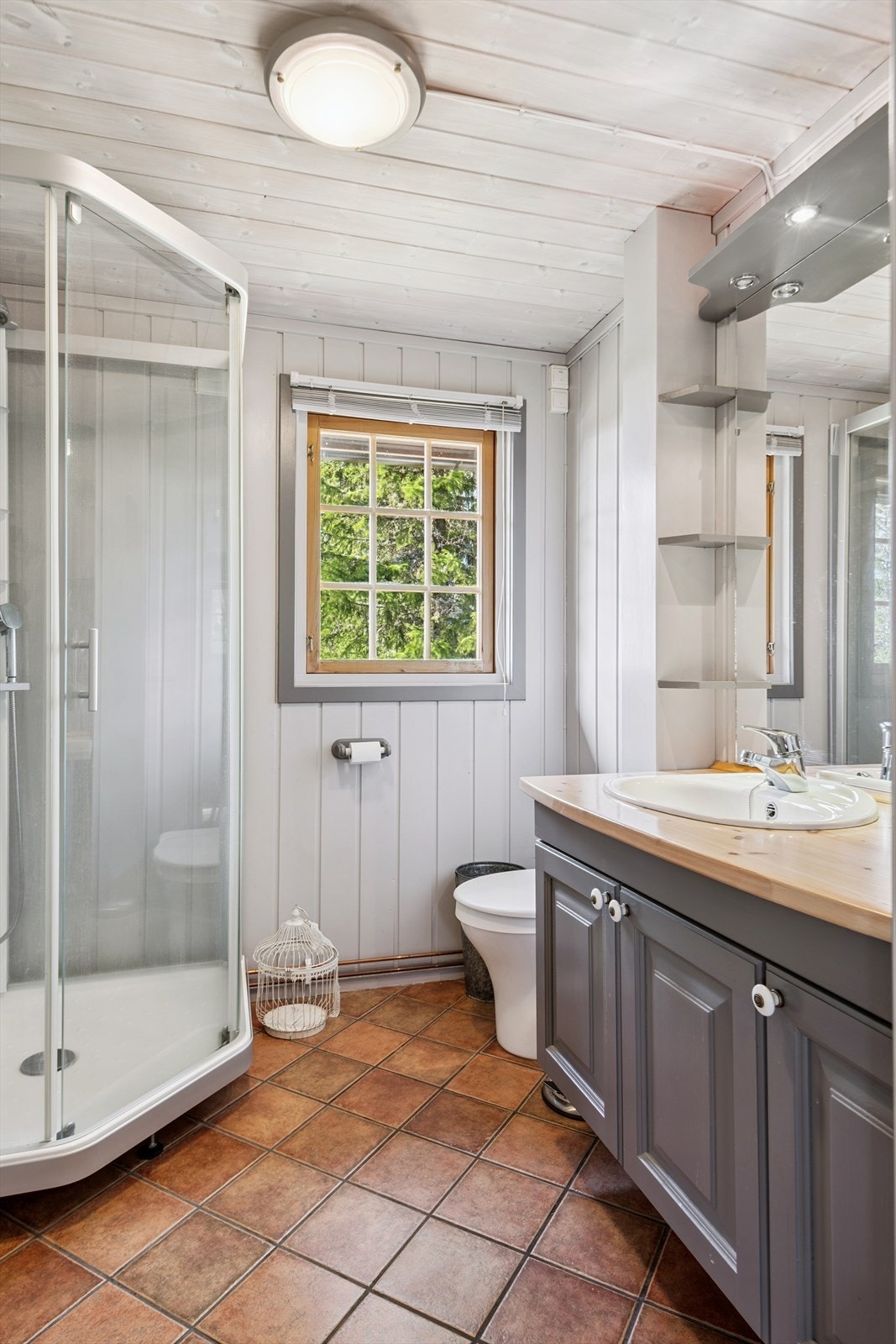 Pent baderom med nedfelt servant i baderomsinnredning, gulvmontert mulltoalett og disjkabinett. Galleribilde