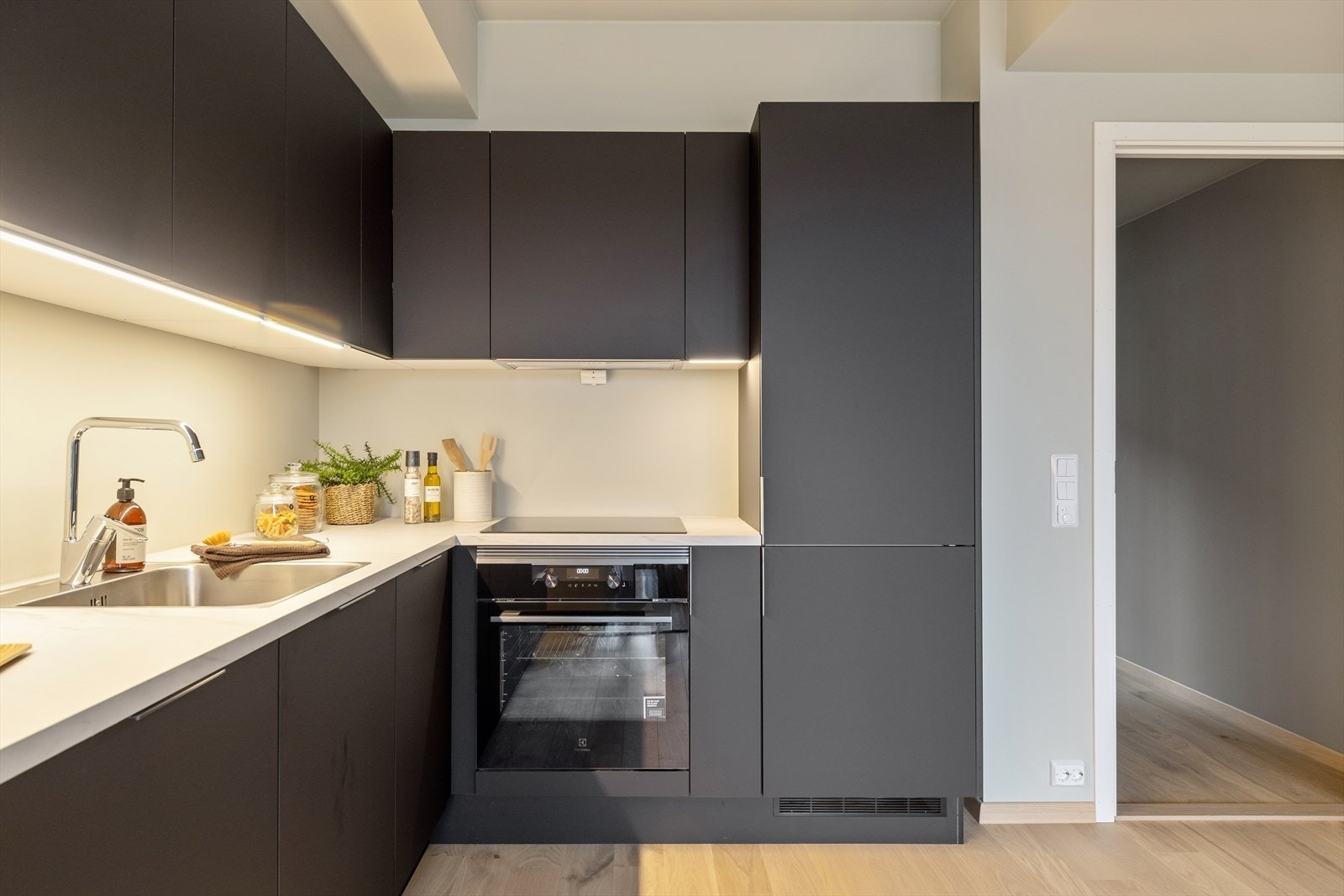 Stilren kjøkkeninnredning med mørke fronter gir kjøkkenet et ryddig og effektivt arbeidsområde. Galleribilde