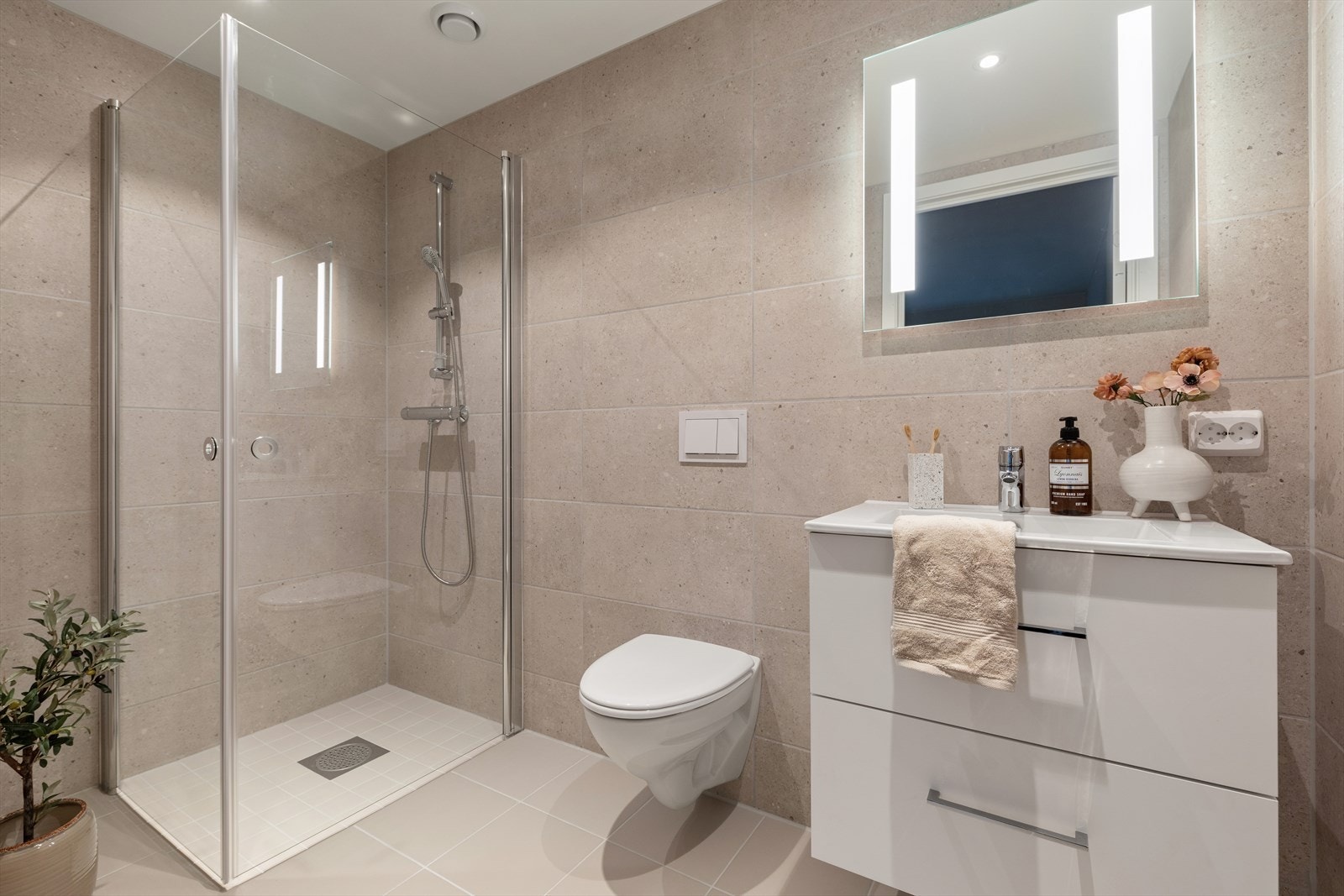 Dusjnisje med glassvegger og vegghengt toalett gir et moderne preg til badet. Galleribilde