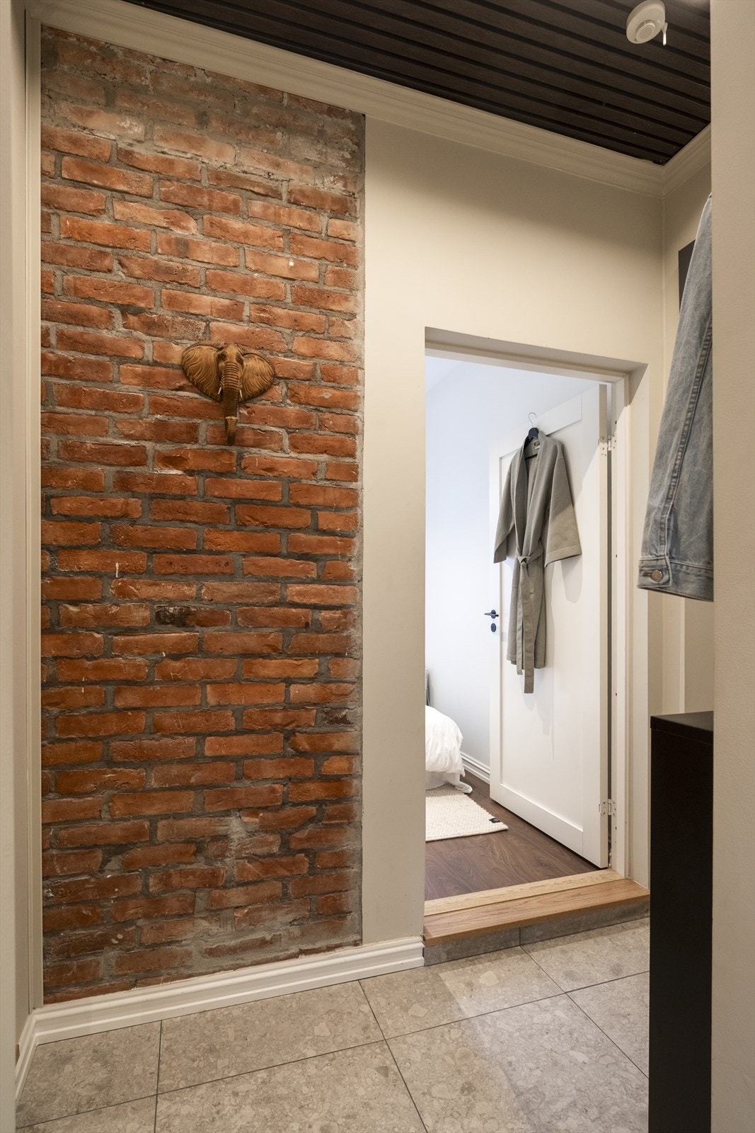 En eksponert teglsteinsvegg tilfører rommet en rustikk og særpreget karakter. Galleribilde