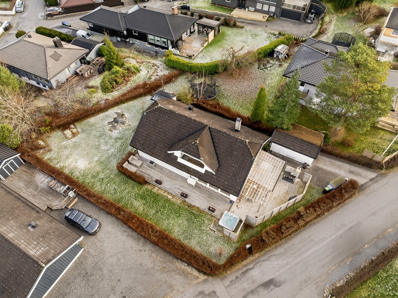 Barnevennlig tomt som er opparbeidet med gressarealer, beplantning, belegningsstein og treplattinger/terrasse. Galleribilde