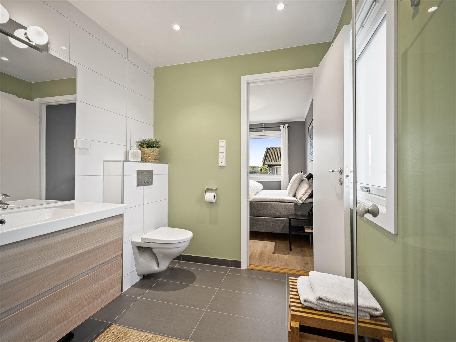 Fra hovedsoverommet er det inngang til eget flislagt bad med behagelig gulvvarme. Badet er utstyrt med badreomsinnredning, vegghengt toalett og dusjnisje Galleribilde