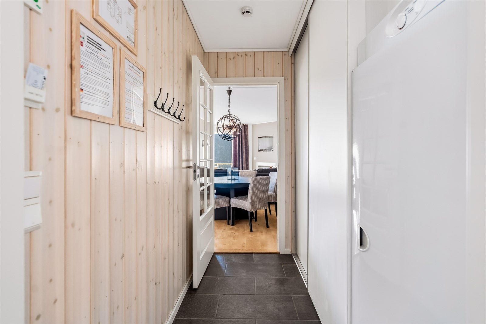 Pent flislagt og utstyrt med en praktisk skyvedørsgarderobe som gir rikelig med oppbevaringsplass, samt et romslig tørkeskap. Galleribilde