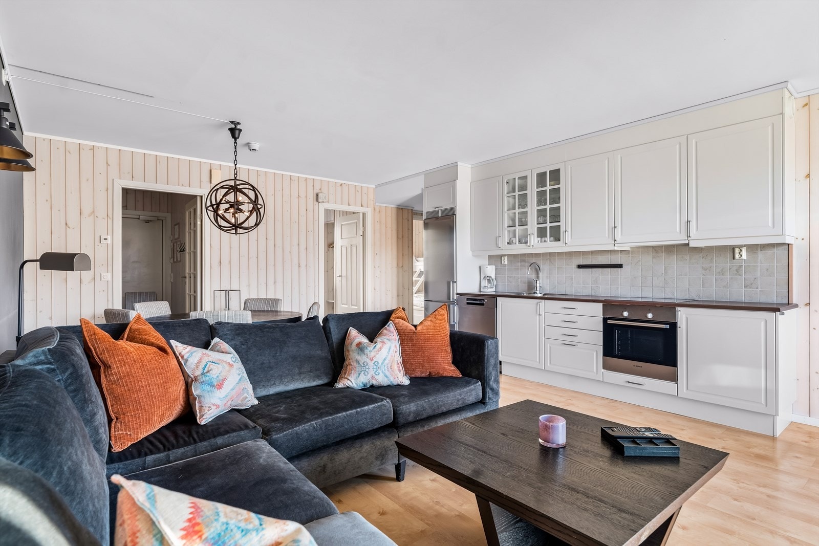 Lys og moderne stue med ettstavs laminatgulv og malte veggflater. Rommet byr på gode møbleringsmuligheter med plass til både spisegruppe og sofakrok. Galleribilde