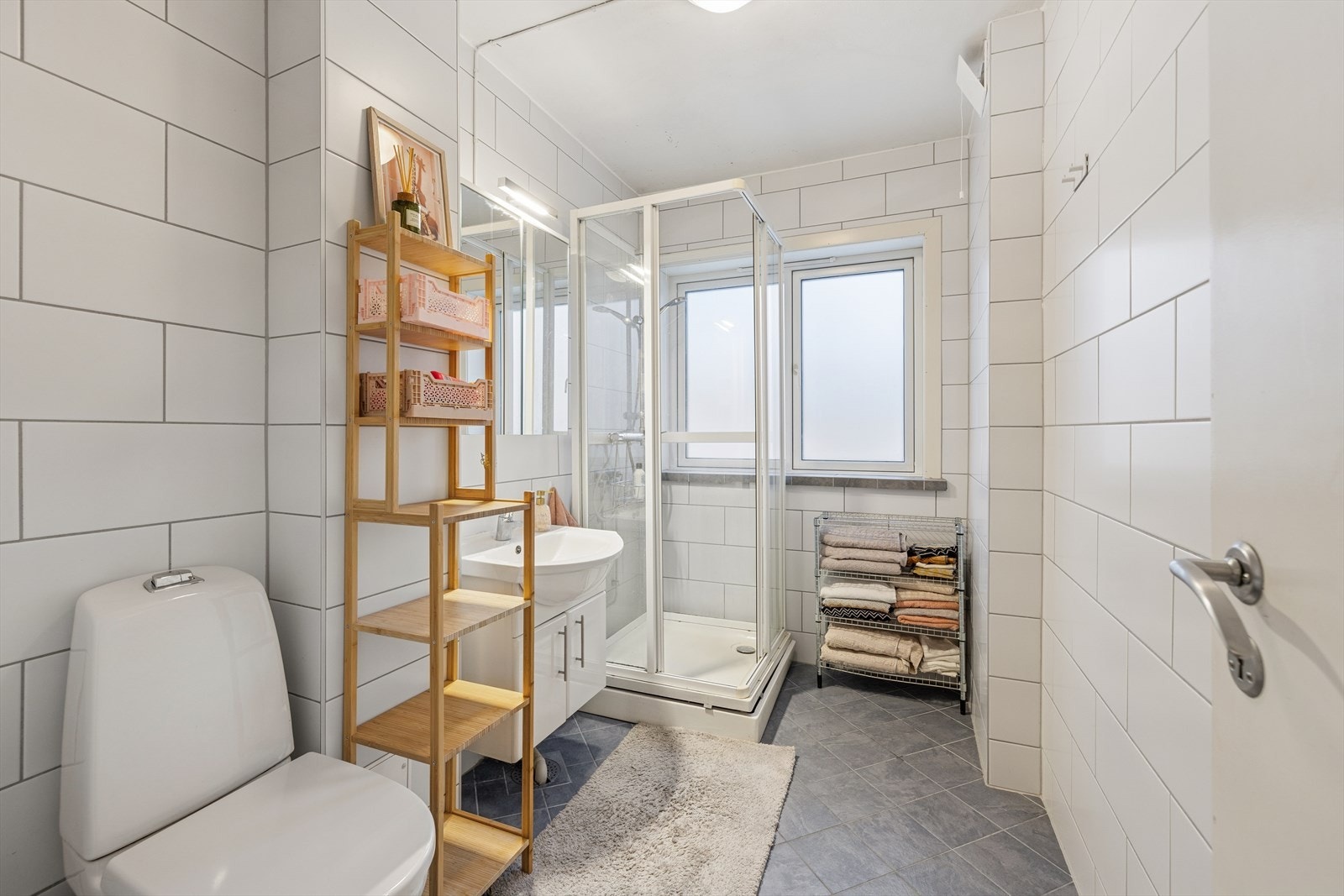 Bad med fliser på vegger og gulv. Det er gulvvarme og radiator som oppvarmingskilde. Galleribilde