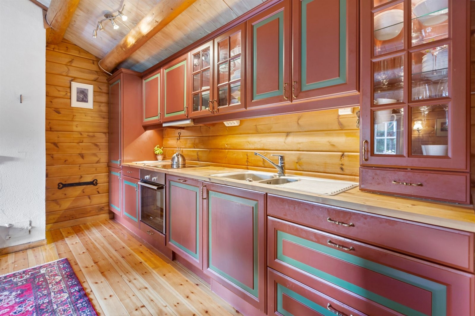 Kjøkkenet har innredning med profilerte fronter. Benkeplaten er av
heltre. Det er kjøl/fryseskap, oppvaskmaskin, platetopp og stekeovn.
Det er kjøkkenventilator med avtrekk ut. Galleribilde