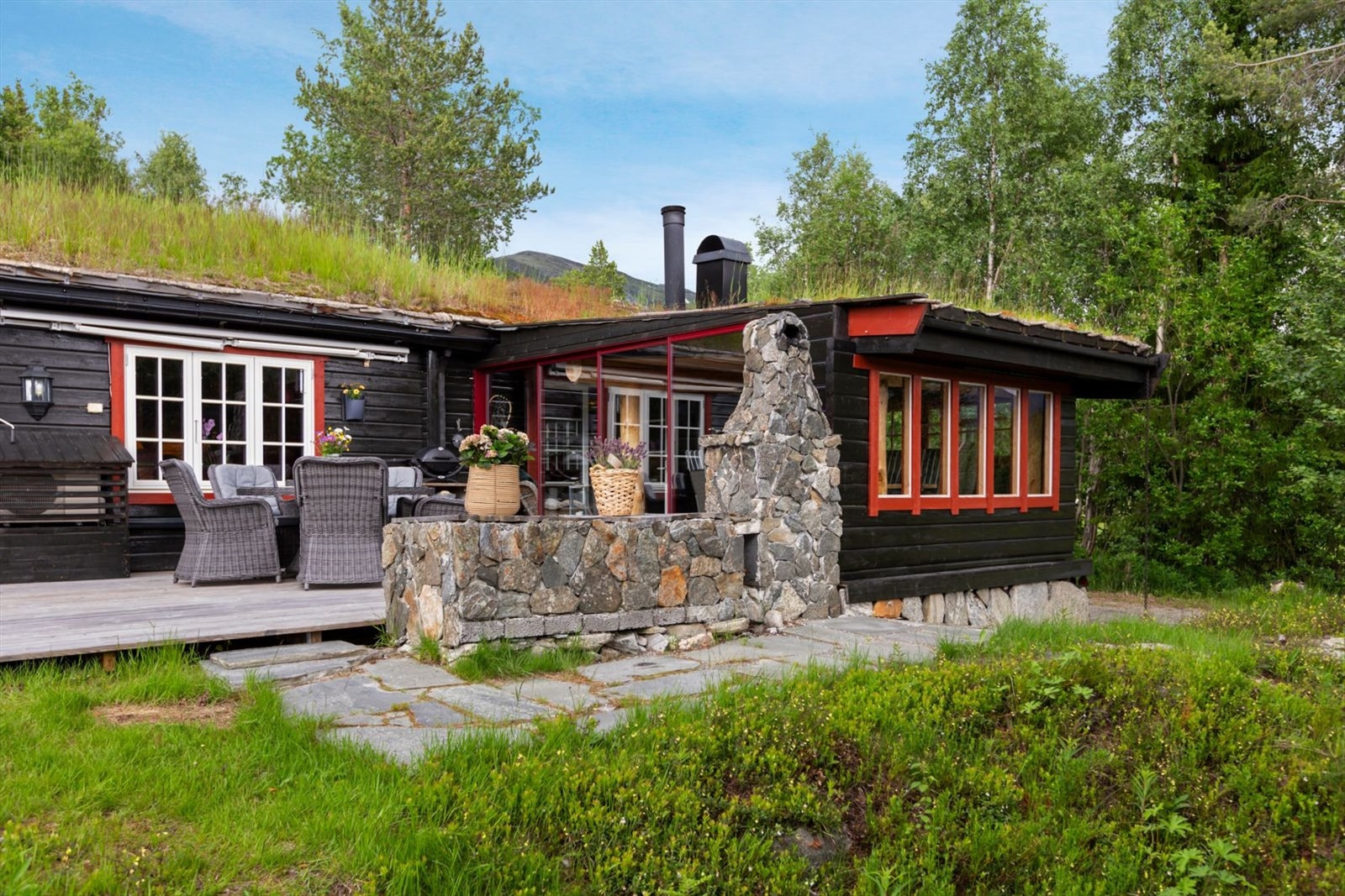 Det er oppført murt peis på terrassen og god adkomst til terreng og hage Galleribilde