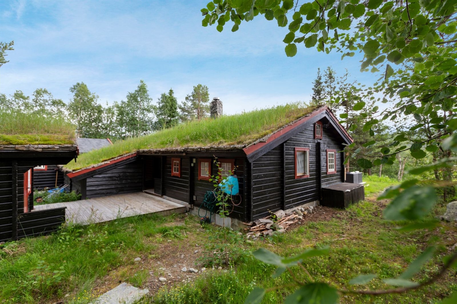 Fasade av hytten, anneks og terrassen i bakkant Galleribilde