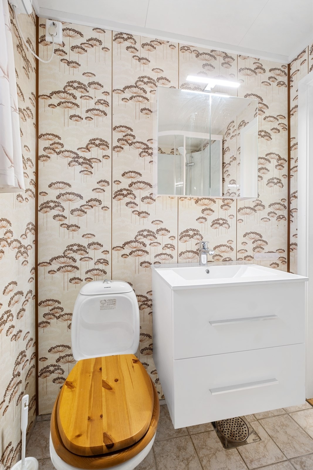 Her finner du toalett, dusjkabinett og baderomsinnredning i hvit utførelse med speilskap over Galleribilde