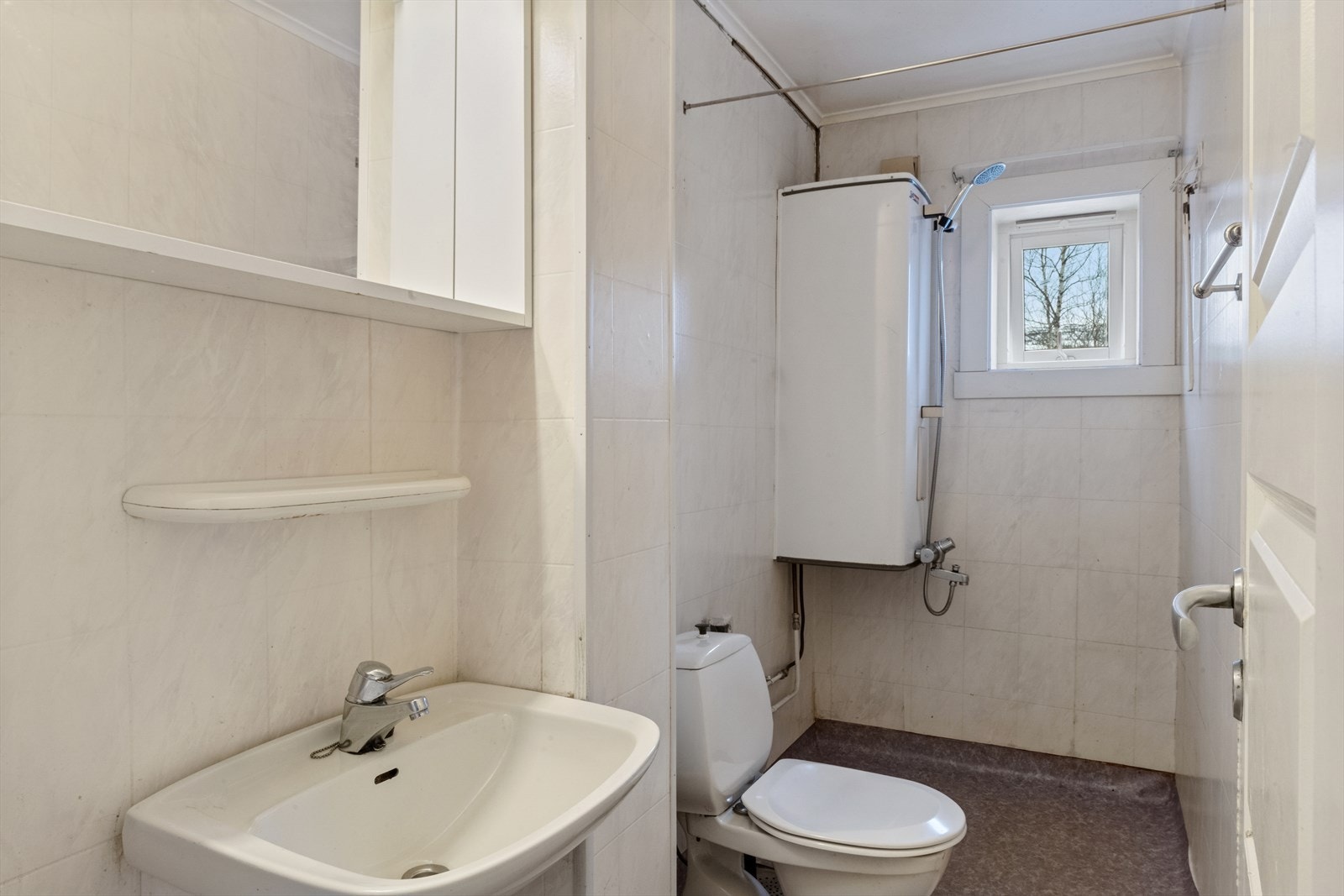 Badet er ellers enkelt innredet med dusjhjørne, toalett og servant. Rommet har kun naturlig ventilasjon via ventil i vegg og mekanisk vifte bør etableres. Galleribilde