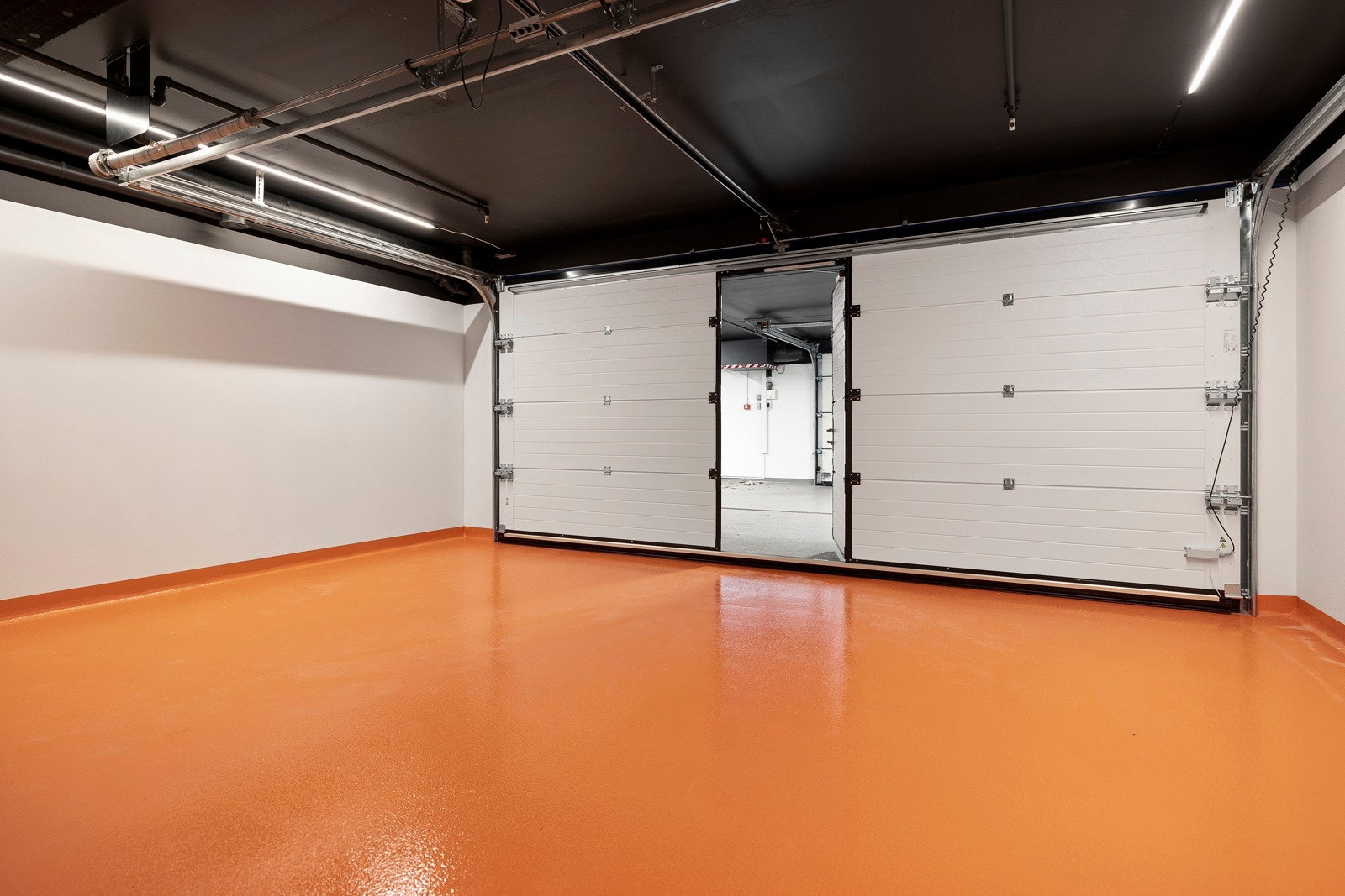 Leiligheten har en dobbelgarasje med egen port i fellesanlegget, og herfra er det direkte inngang til kjelleren. Galleribilde