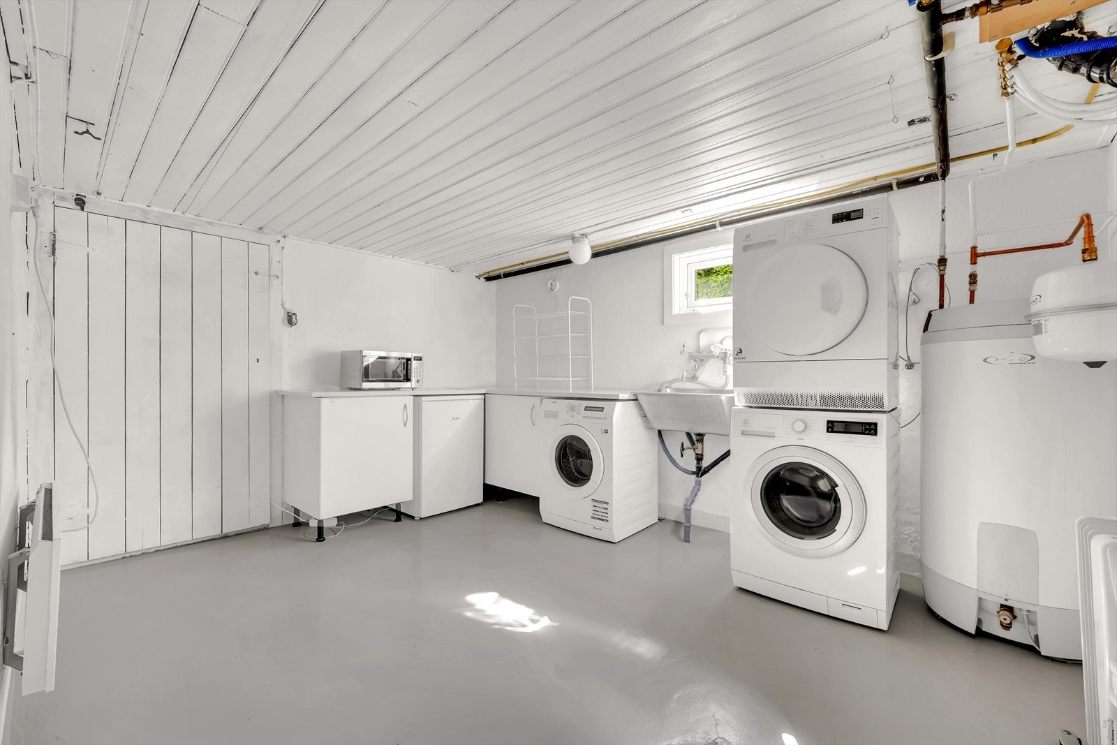 Romslig vaskekjeller. Her er det skyllekar, opplegg til vaskemaskin, laminert innredning. Galleribilde