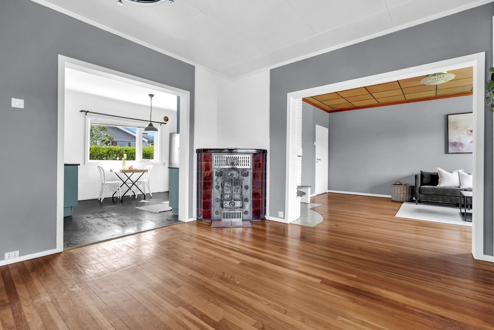 Det er eldre vedkamin for fast brensel montert i stue. Galleribilde