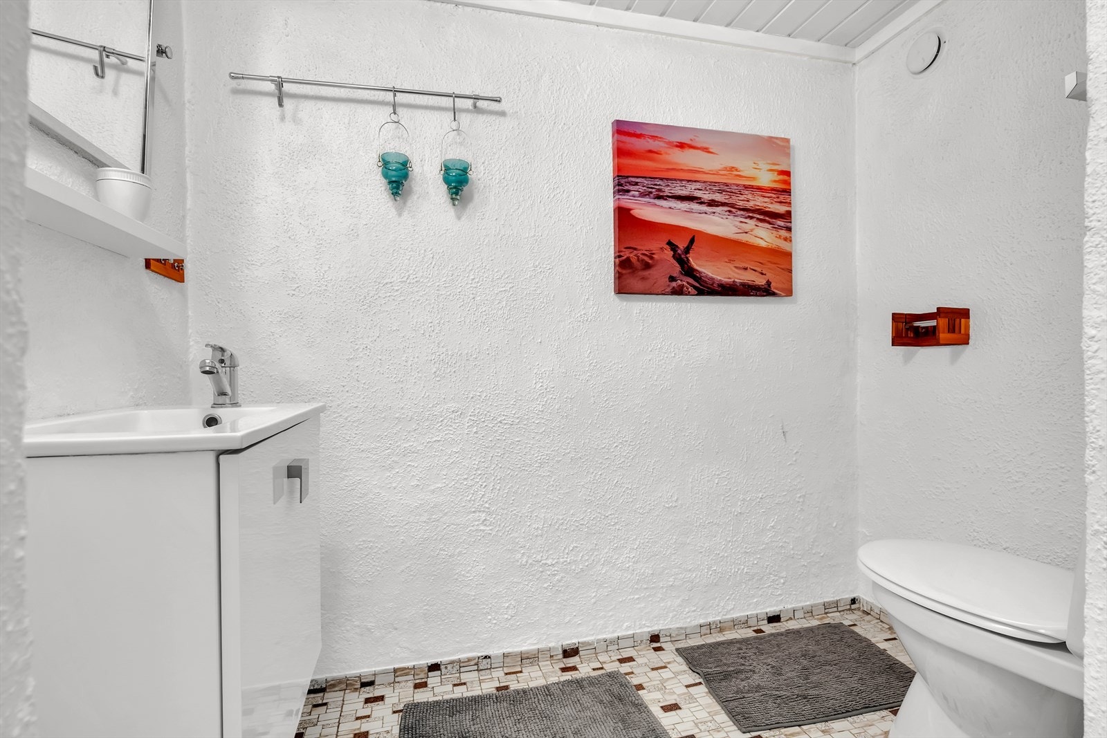 Malt mur på vegg. Malt trepanel i tak. Toalett og servant med servantskap. Galleribilde