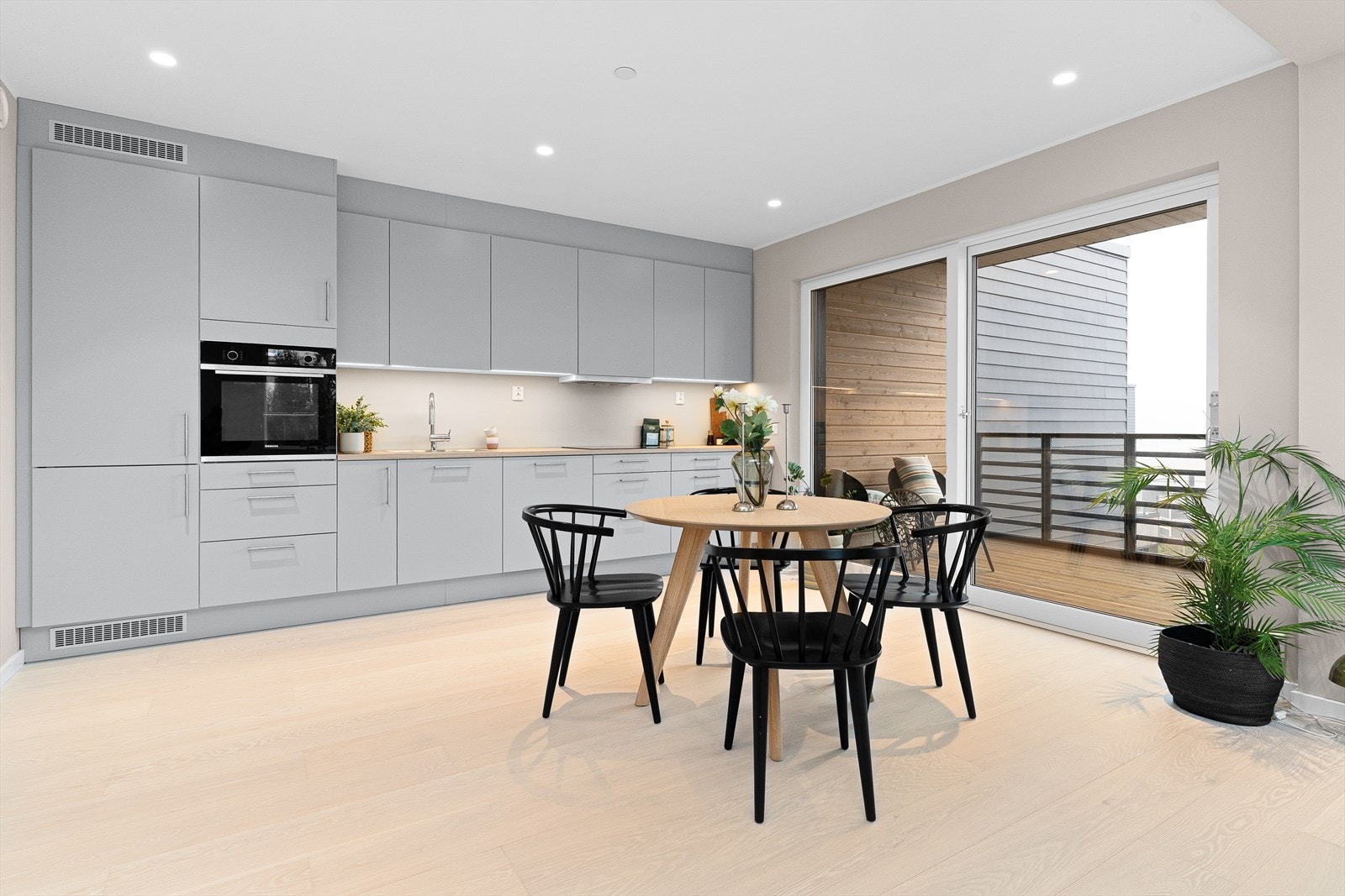 Klassisk og moderne kjøkkeninnredning med grå slette fronter og benkeplate av laminat. Galleribilde