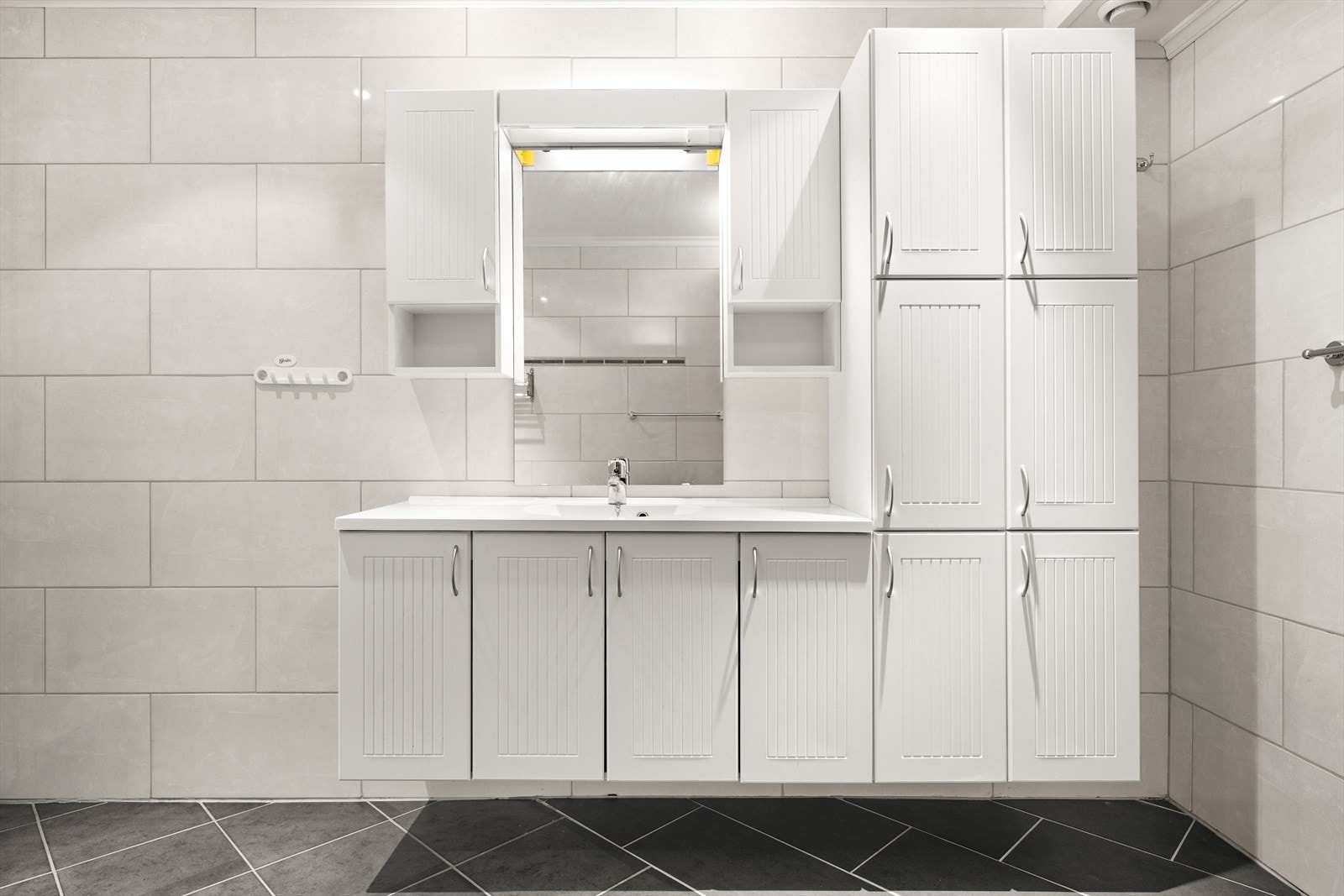 Badet har innredning med innredning med nedfelt servant med godt med skaper, dusjkabinett og badekar. Galleribilde