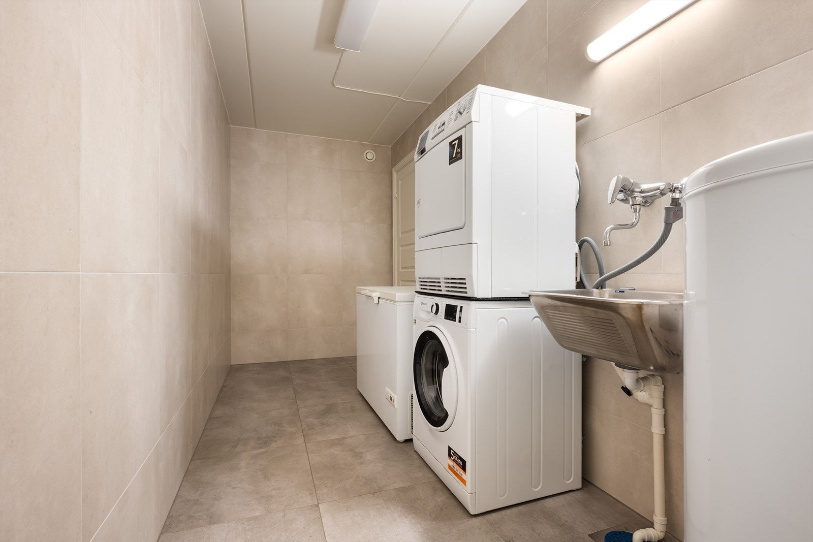 Praktisk vaskerom med fliser på gulv og vegger. Utslags kum. Galleribilde