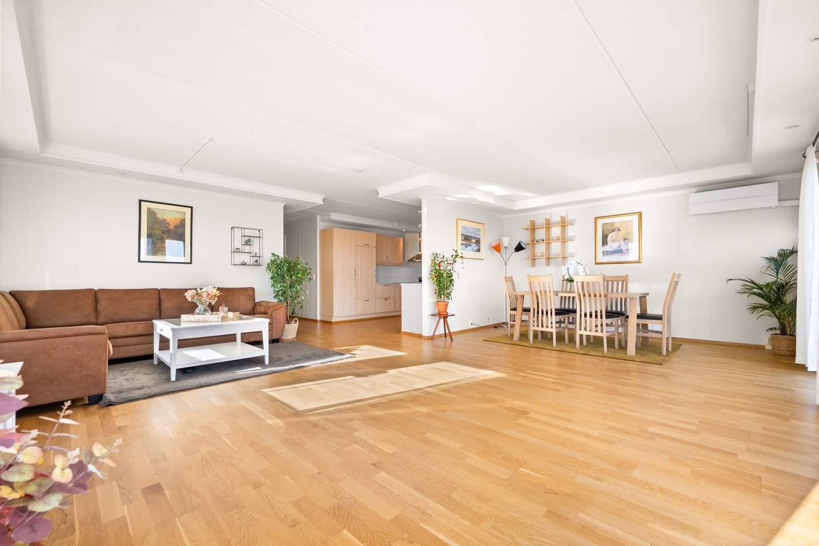 Romslig stue med parkett på gulv, malte plater på vegger og malte plater i taket. Her er det god plass til flere soner til møblering. Galleribilde