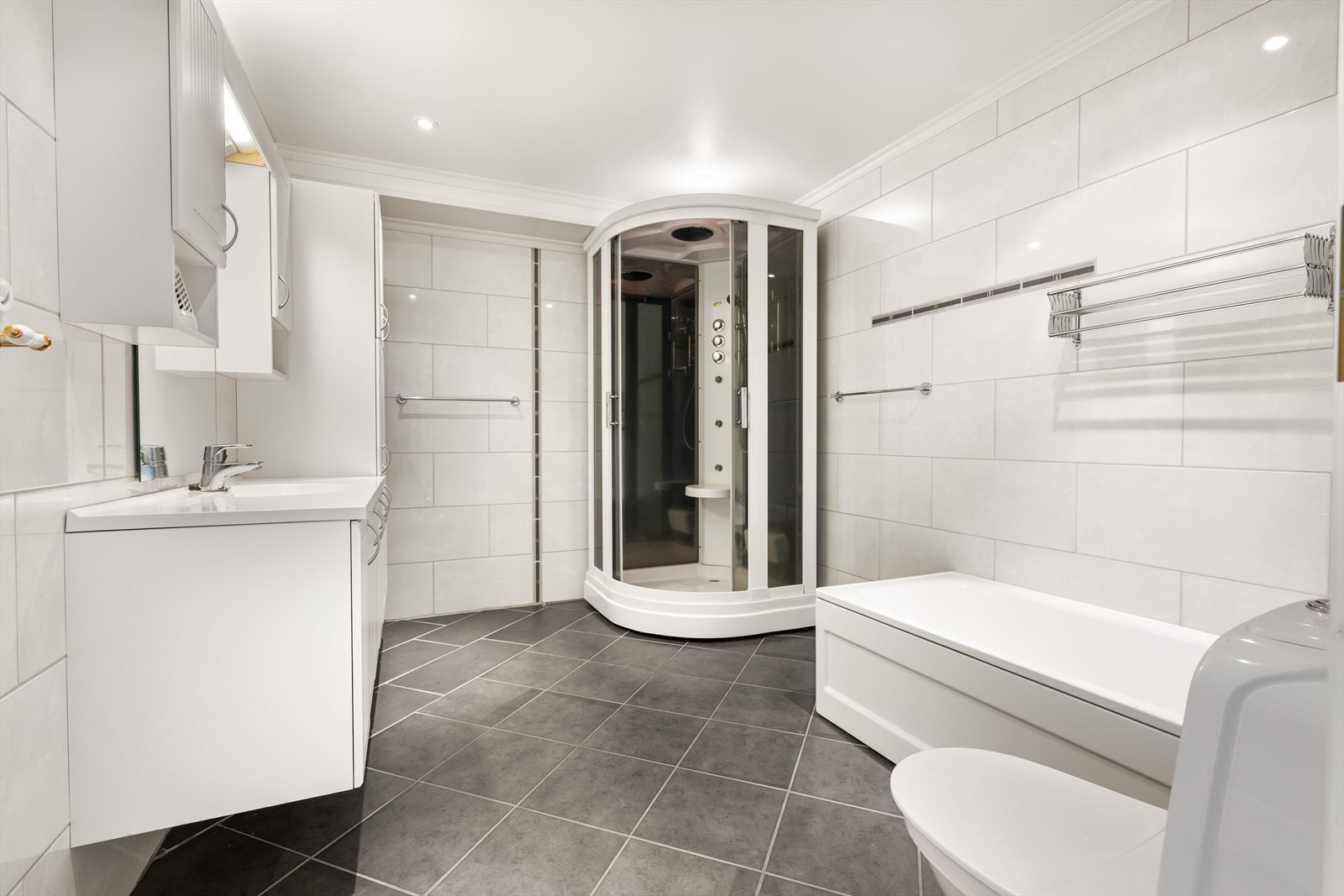 Romslig bad med godt med plass til oppbevaring. Galleribilde