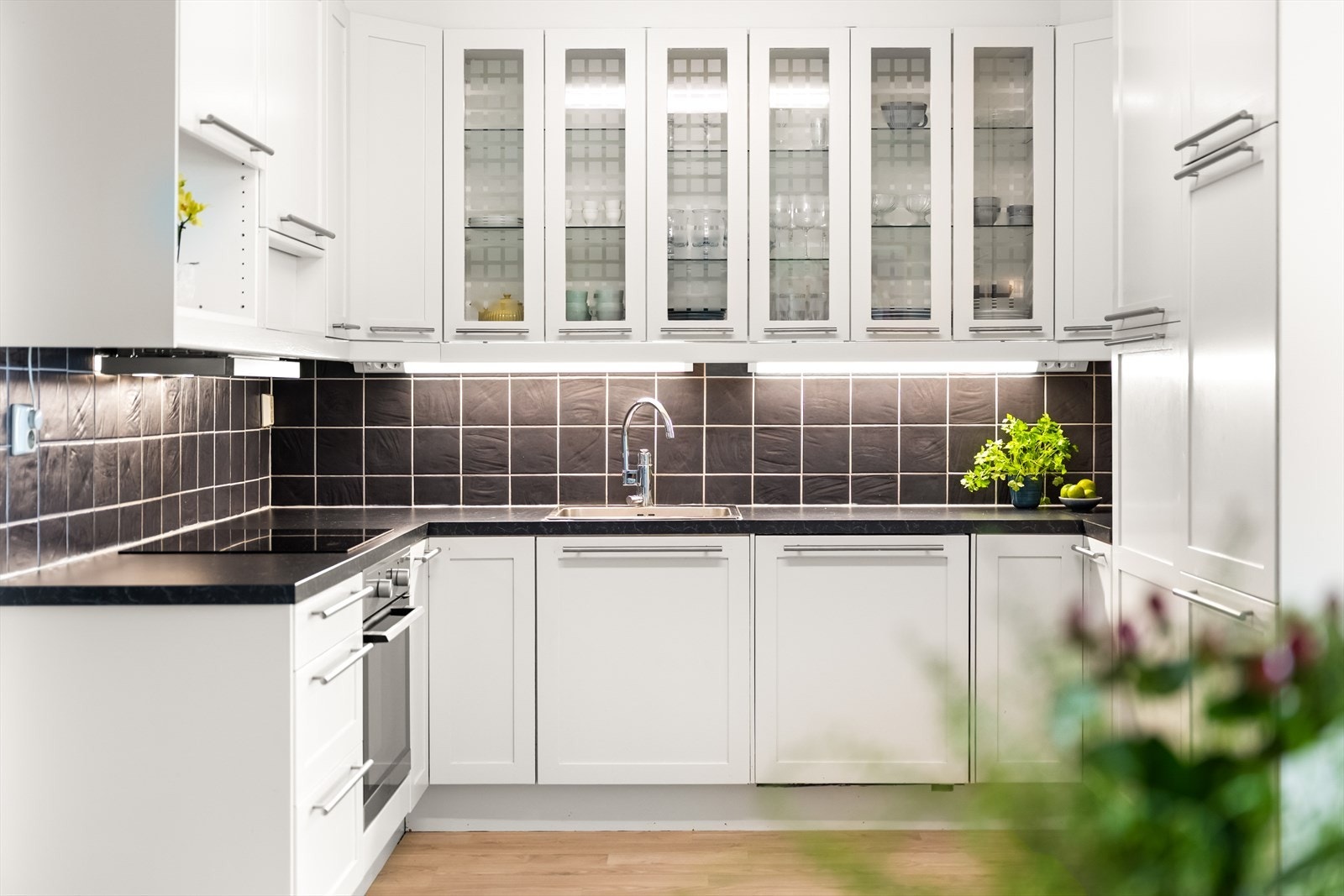 Klassisk kjøkkeninnredning med hvite profilerte fronter og benkeplate av laminat. Galleribilde