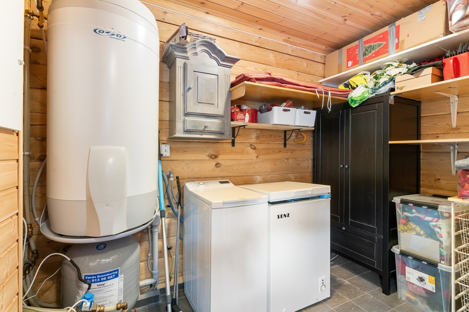 Teknisk rom med opplegg til vaskemaskin og plass til ekstra oppbevaring. Galleribilde