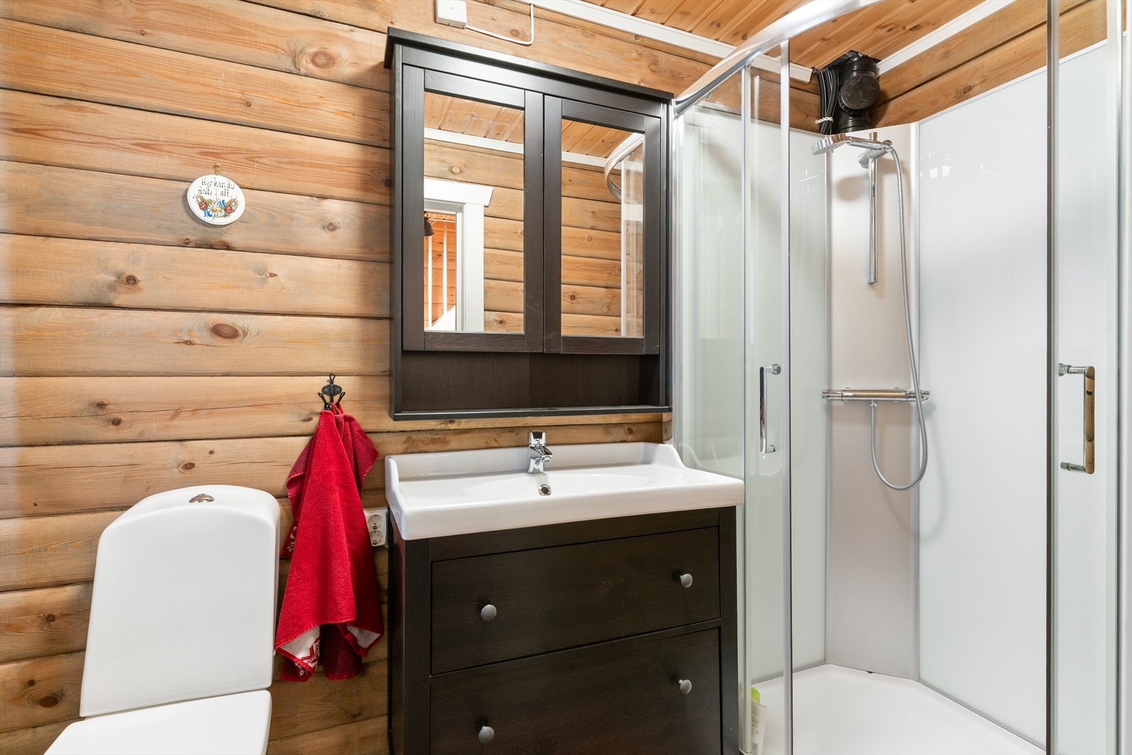 Badet har baderomsinnredning med servant, speilskap, toalett og dusjkabinett. Galleribilde