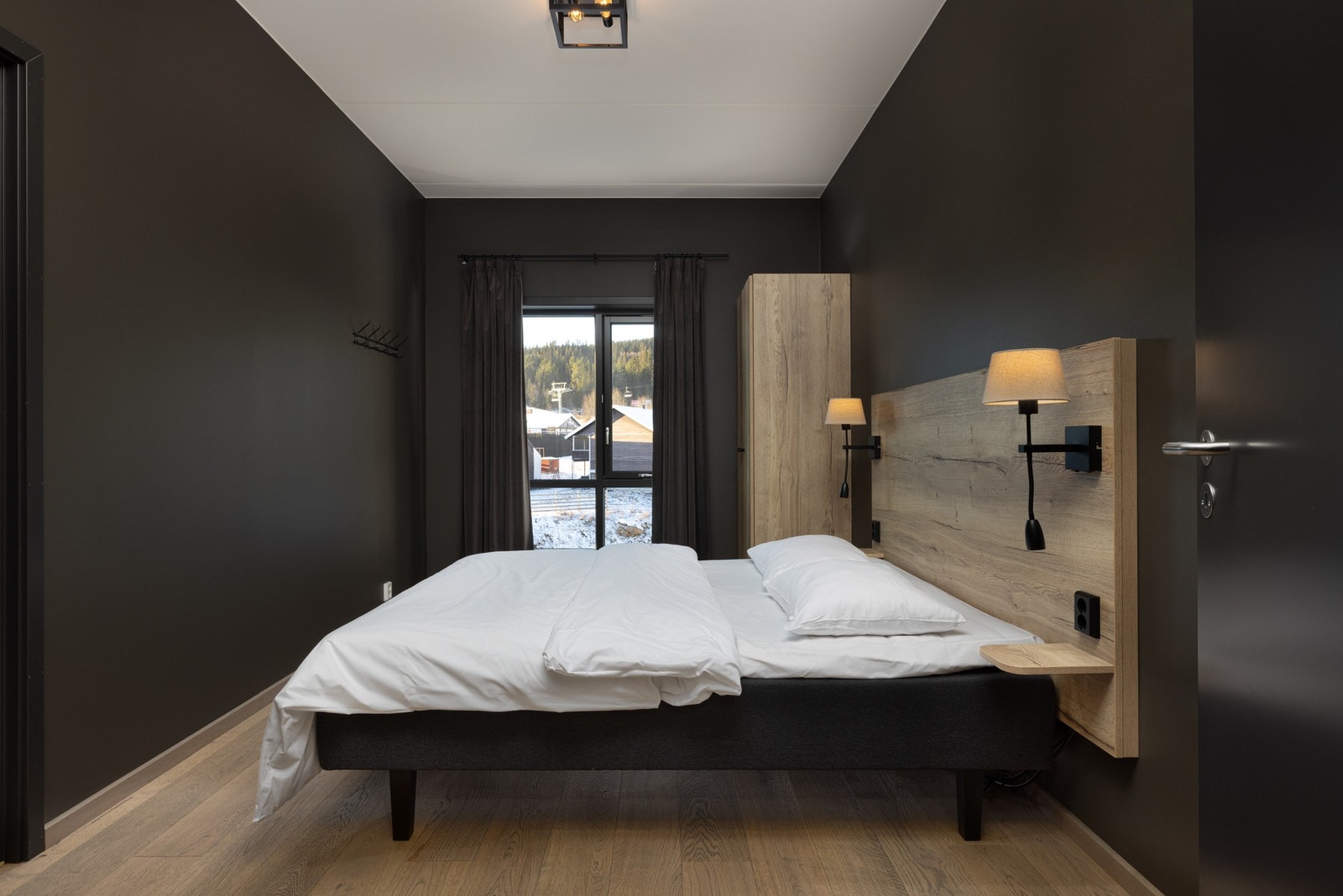 Rommet er utstyrt med dobbeltseng, to garderobeskap og veggmontert sengegavl med nattbord. Galleribilde