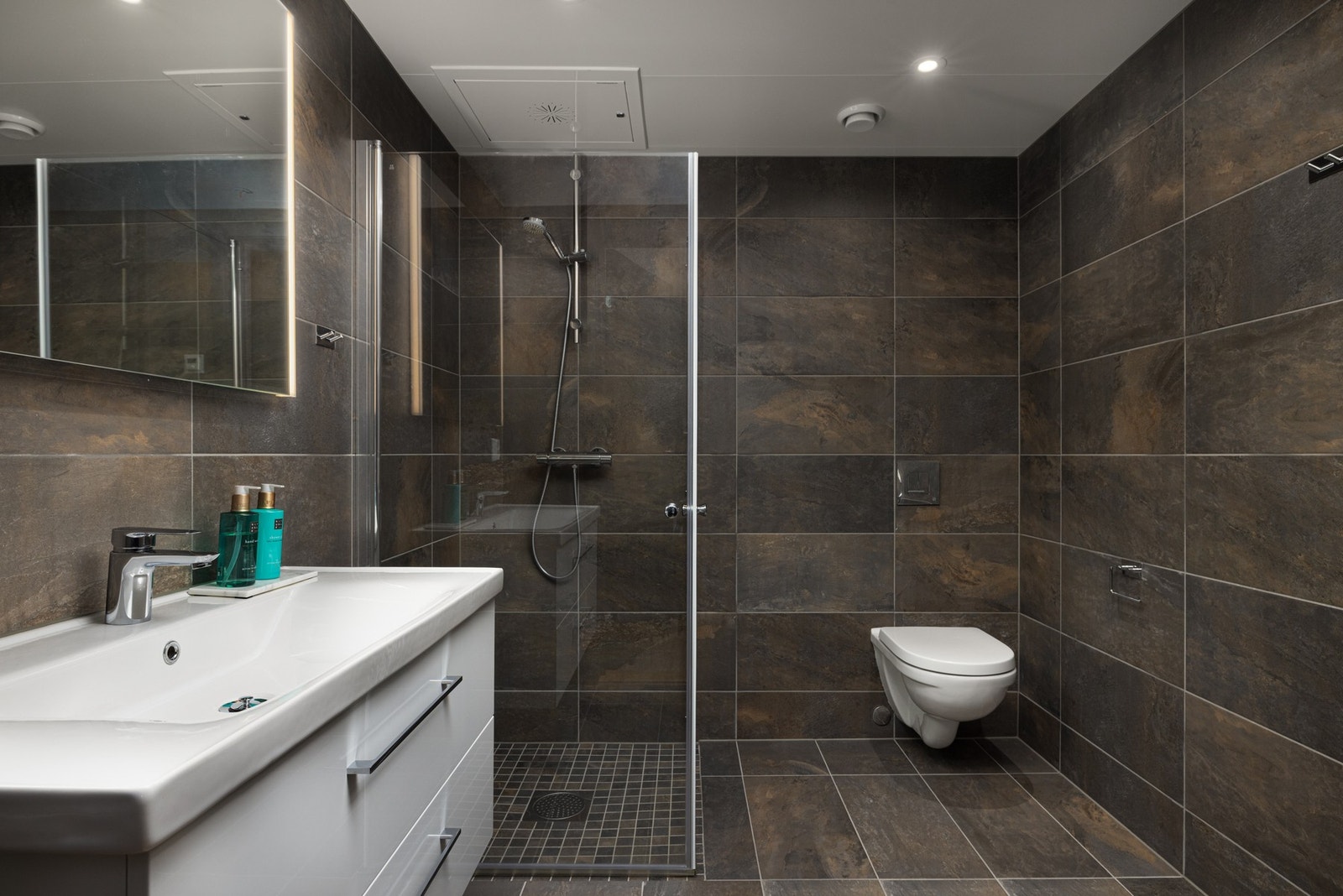 Badet tilknyttet hovedsoverommet har flislagte vegger og gulv med vannbåren gulvvarme. Galleribilde