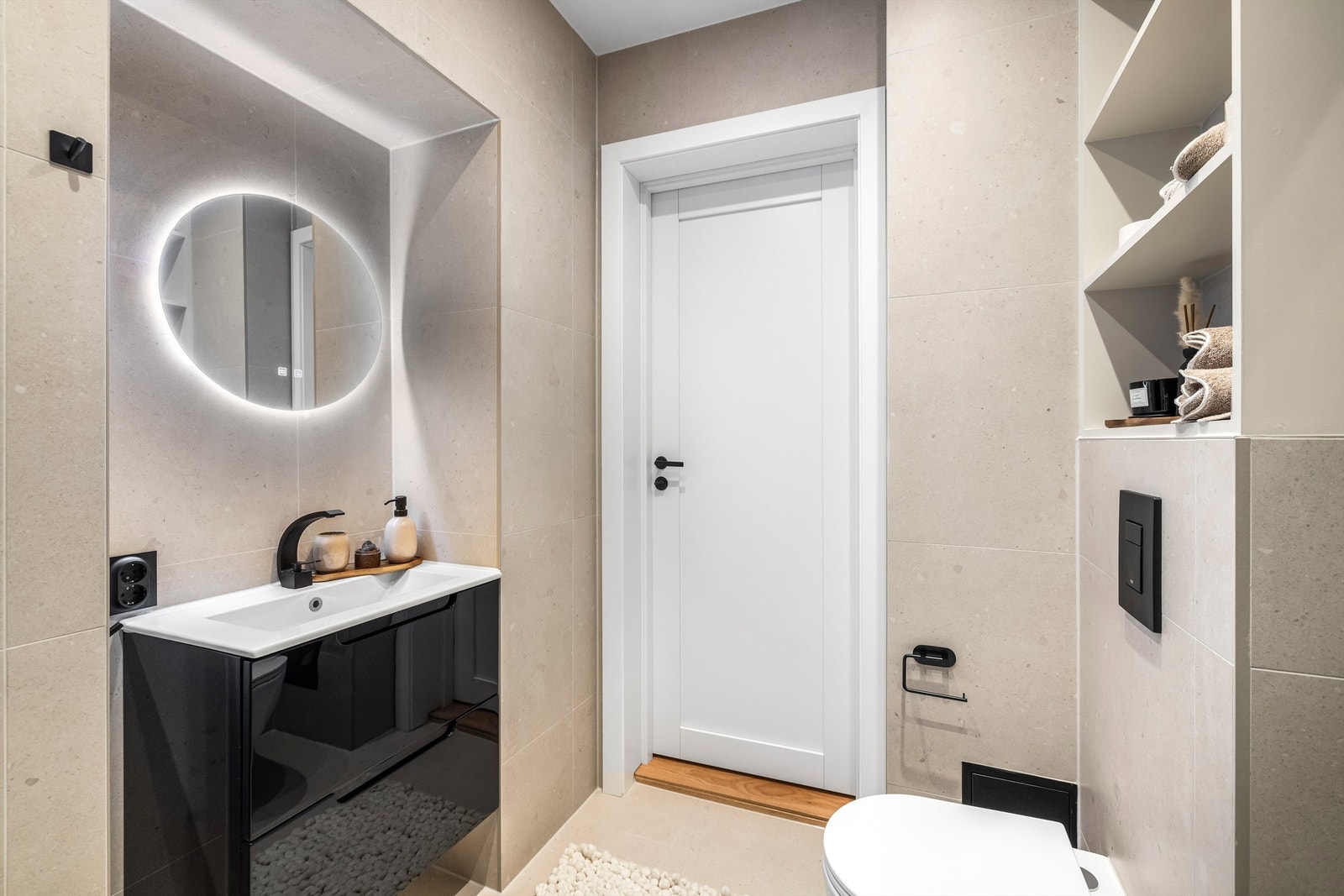 Baderomsinnredning med servant og et elegant, bakbelyst speil. Galleribilde