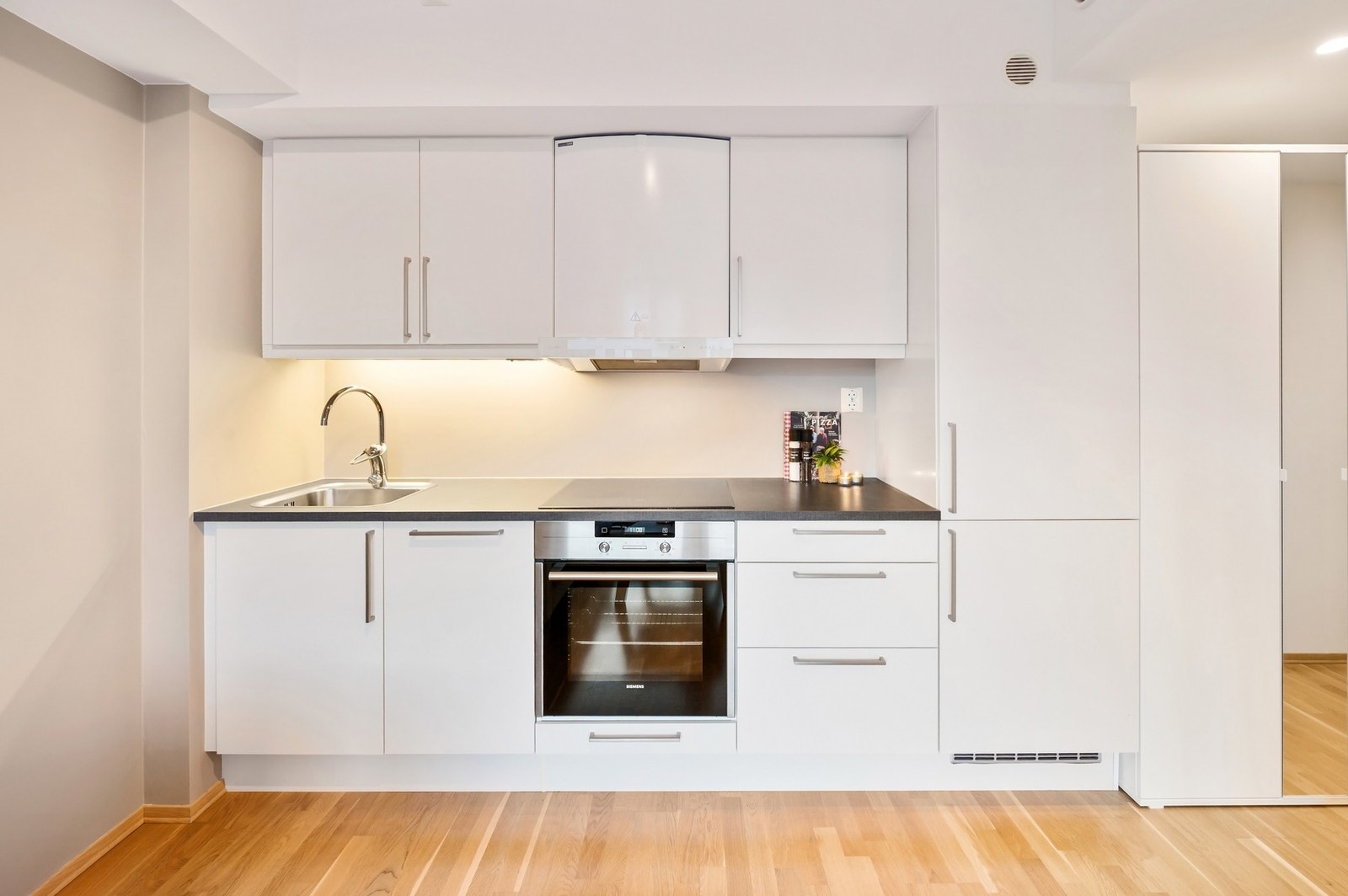 Kjøkkeninnredning med plane fronter og nyere laminert benkeplate. Galleribilde