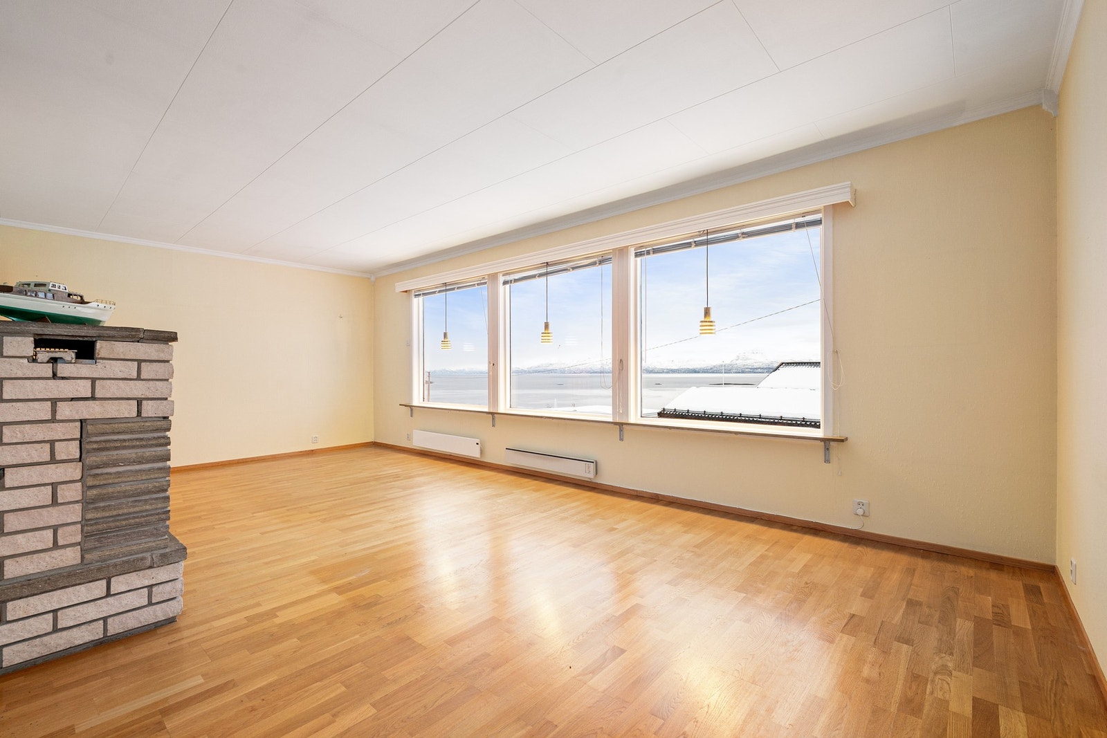 Romslig stue med store stuevinduer i front som gir nydelig utsikt og godt lysinnslipp Galleribilde