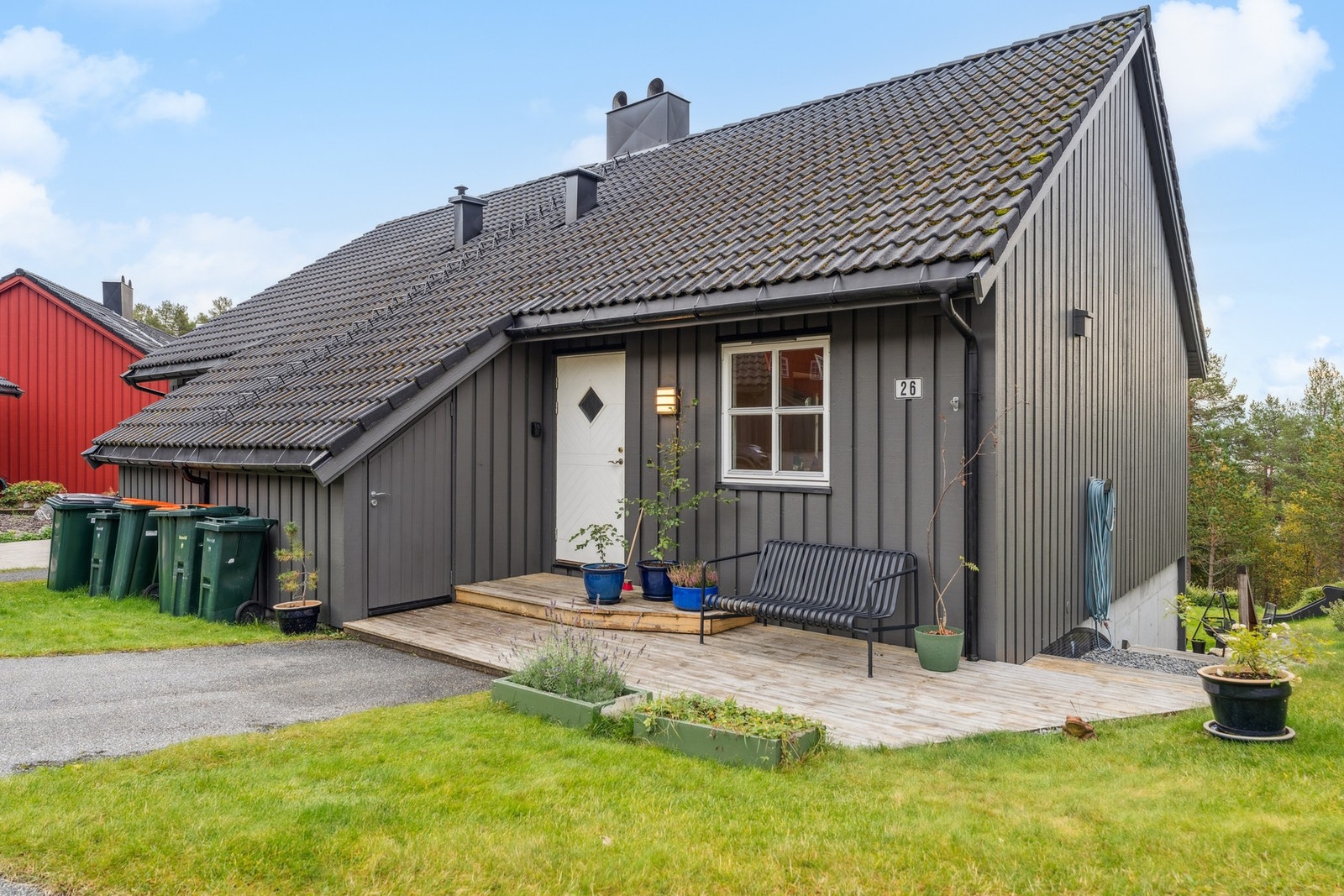 Inngangsparti med koselig platting. Utebod praktisk plassert ved inngang. Utvendig trapp ned til hage på høyre side Galleribilde