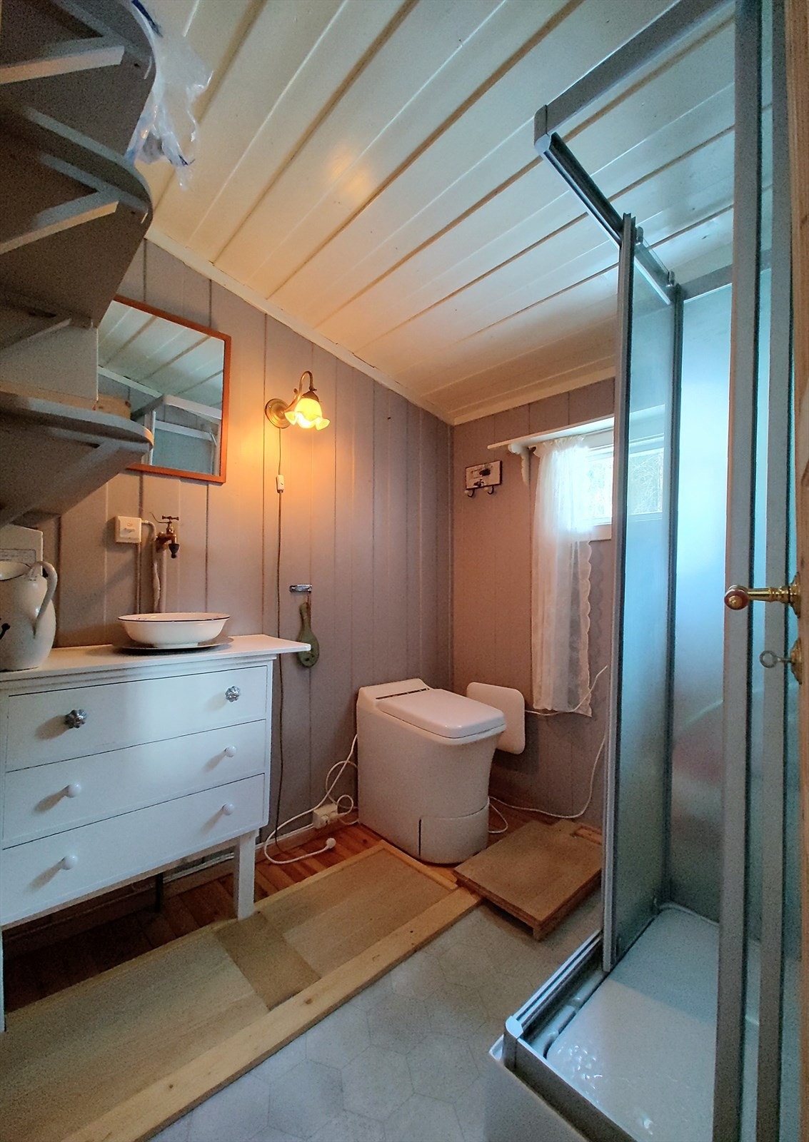 Badet er innredet med Cinderella forbrenningstoalett samt dusjkabinett. Vannkran på vegg med varmekabel. Galleribilde