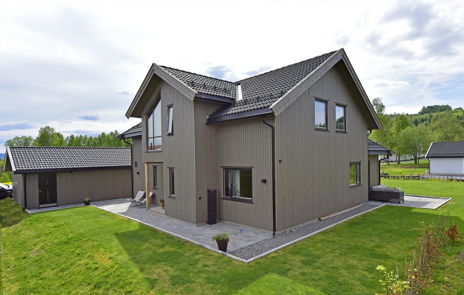 Eiendommen har en opparbeidet tomt med plen og asfaltert gårdsplass, samt en romslig garasje med egen smørebod/bod. Galleribilde