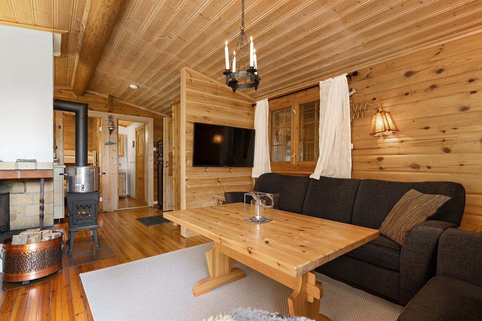 Sentralt i rommet er den varmende og koselige peisen, som gir god varme til hytta. Galleribilde