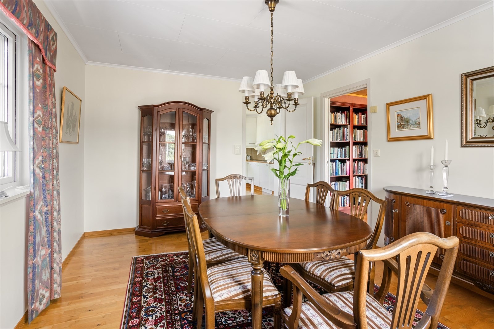 Den adskilte spisestuen ligger flott plassert i fin sammenheng med hjemmets romsilge kjøkken. Det er direkte inngang fra kjøkkenet, i tillegg er det skyvedør inn til bibliotek/mediarom. Galleribilde