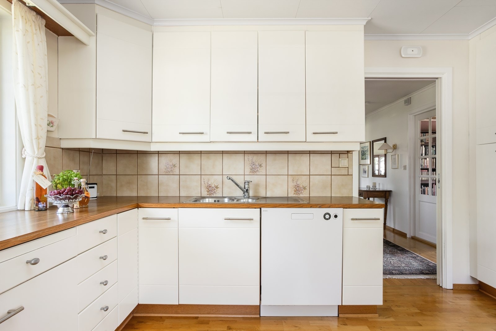 Kjøkkenet har en Innholdsrikt og pent tilpasset kjøkkeninnredning med malte trefronter hvor det bys på godt med skap- og benkeplass ved klassisk "L-løsning". L-løsningen sørger også for god arbeidsplass Galleribilde