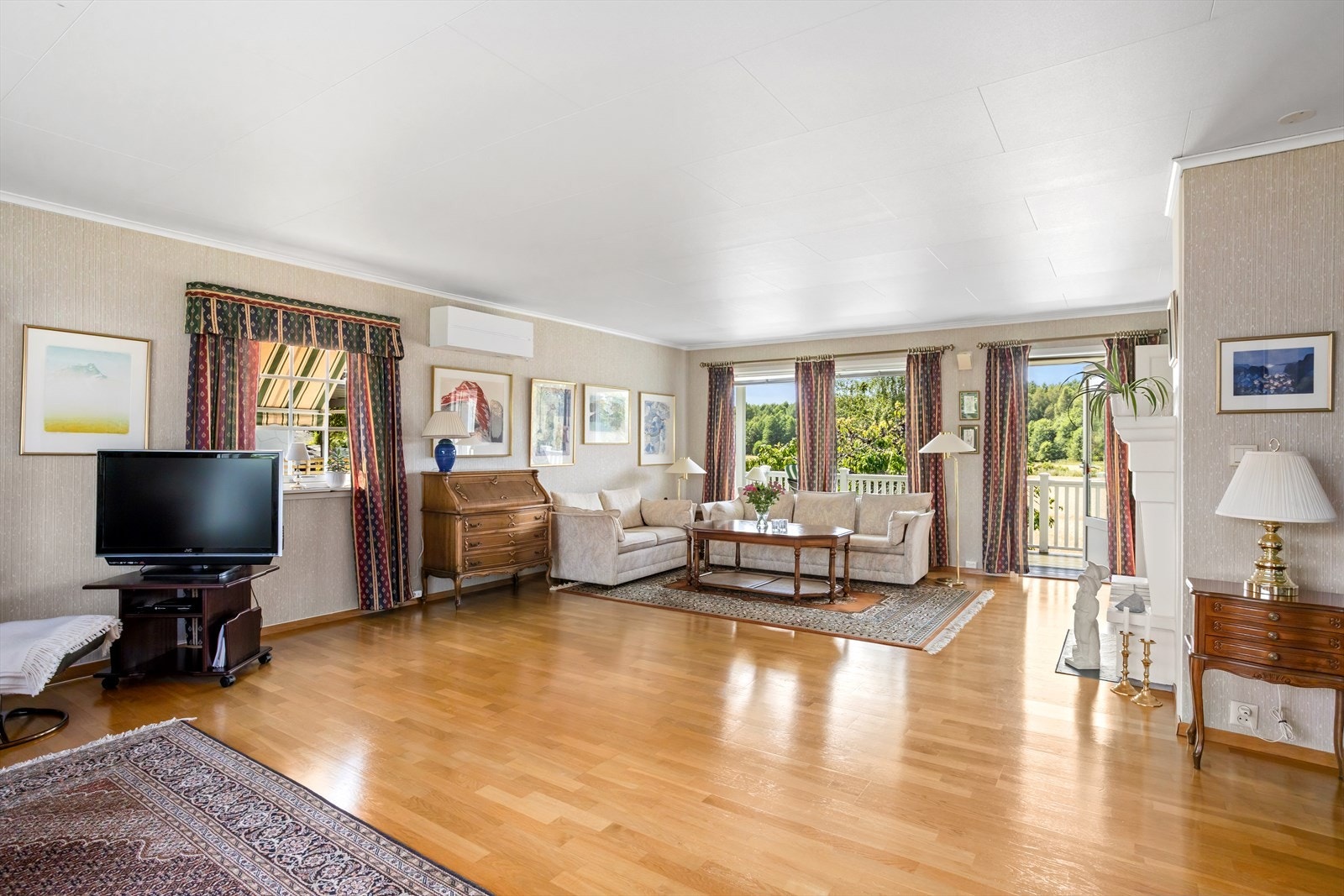 Romslig HOVEDSTUE med blant annet peis og terrassedør som leder ut til stor sammenhengende terrasse på ca. 38 m² for etasjen mot syd, vest og nord. Galleribilde