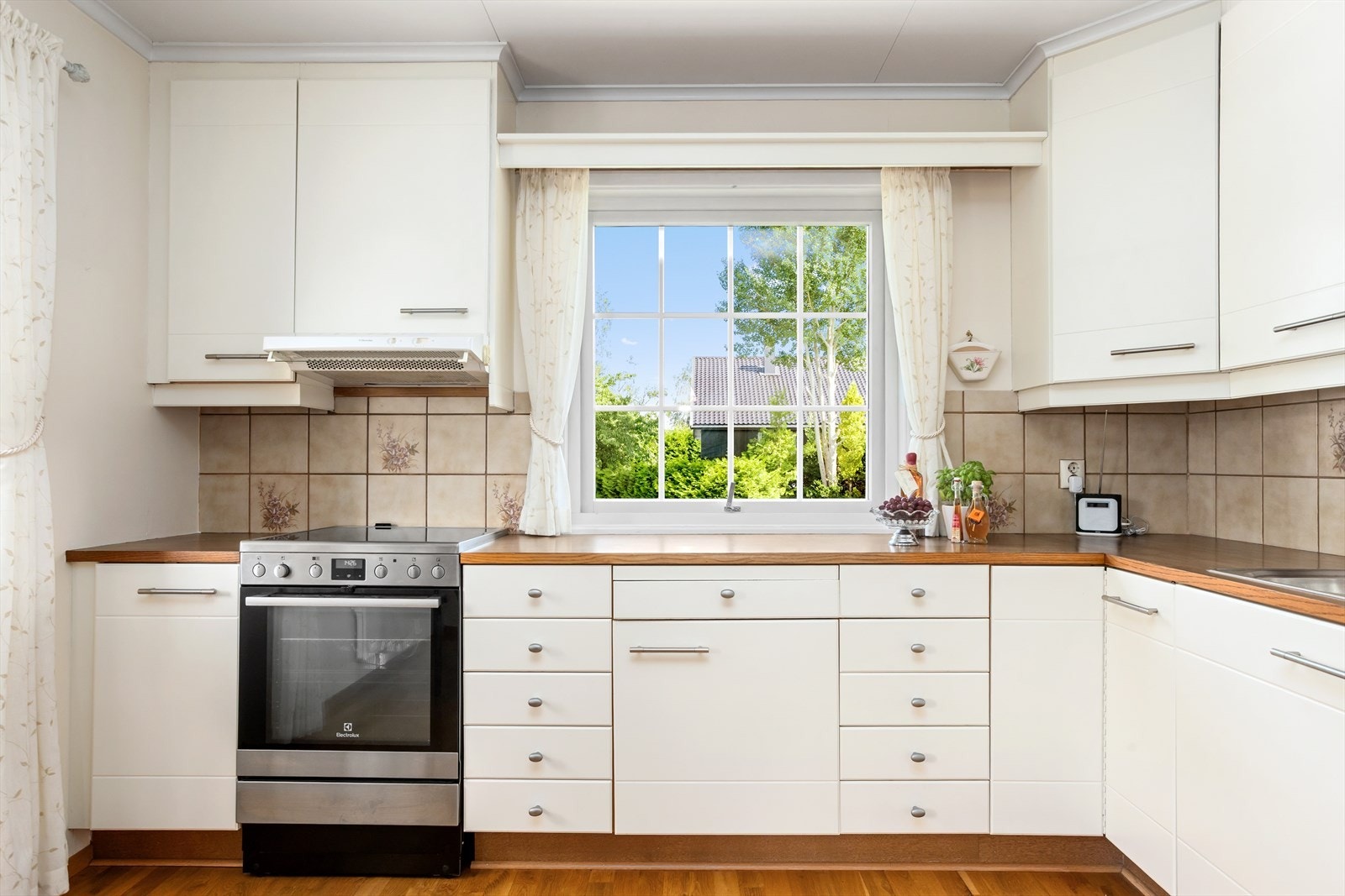 Fra kjøkkenet kan man kokkelere i ro og fred, likevel har man også en fin sosial kontakt med gjester og familiemedlemmer i den tilknyttede spisestuen. Galleribilde