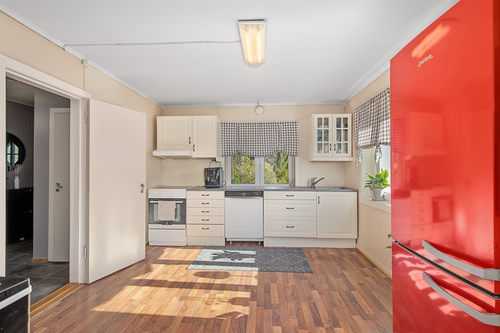 Tidløs kjøkkeninnredning med lyse profilerte fronter. Et stort kjøkken med god plass. Galleribilde