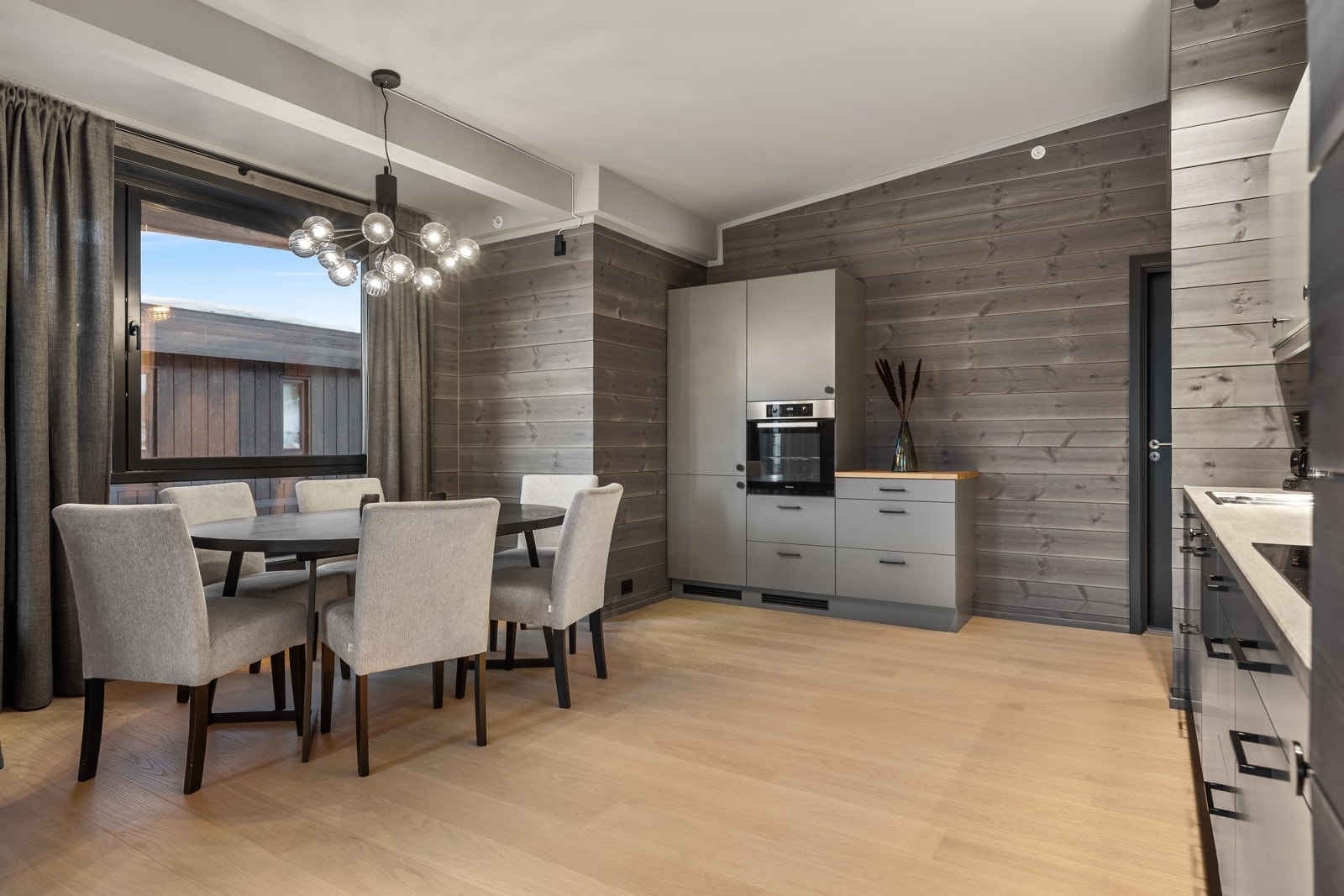 Kjøkkeninnredningen har glatte fronter, heltre benkeplate og integrerte hvitevarer fra kvalitetsleverandøren Miele. Spisestuesonen er innredet med en flott spisegruppe som medfølger. Galleribilde