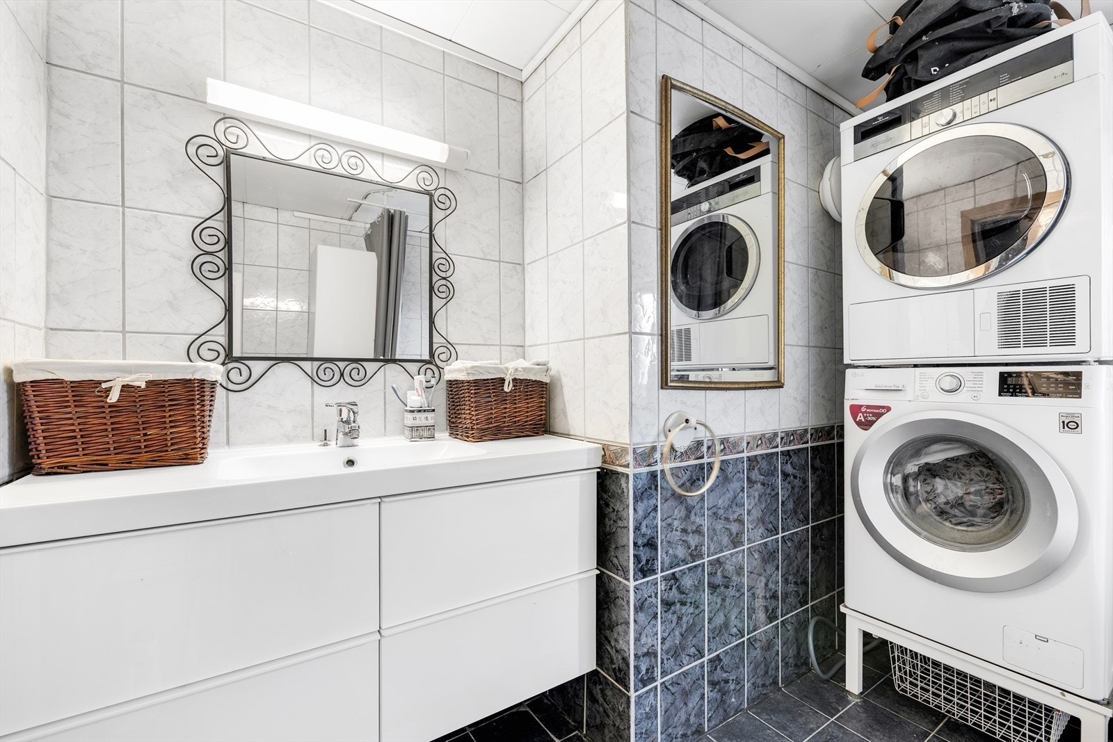 Badet er innredet med servant, klosett, vaskemaskin, tørketrommel, og badekar med dusj. Galleribilde