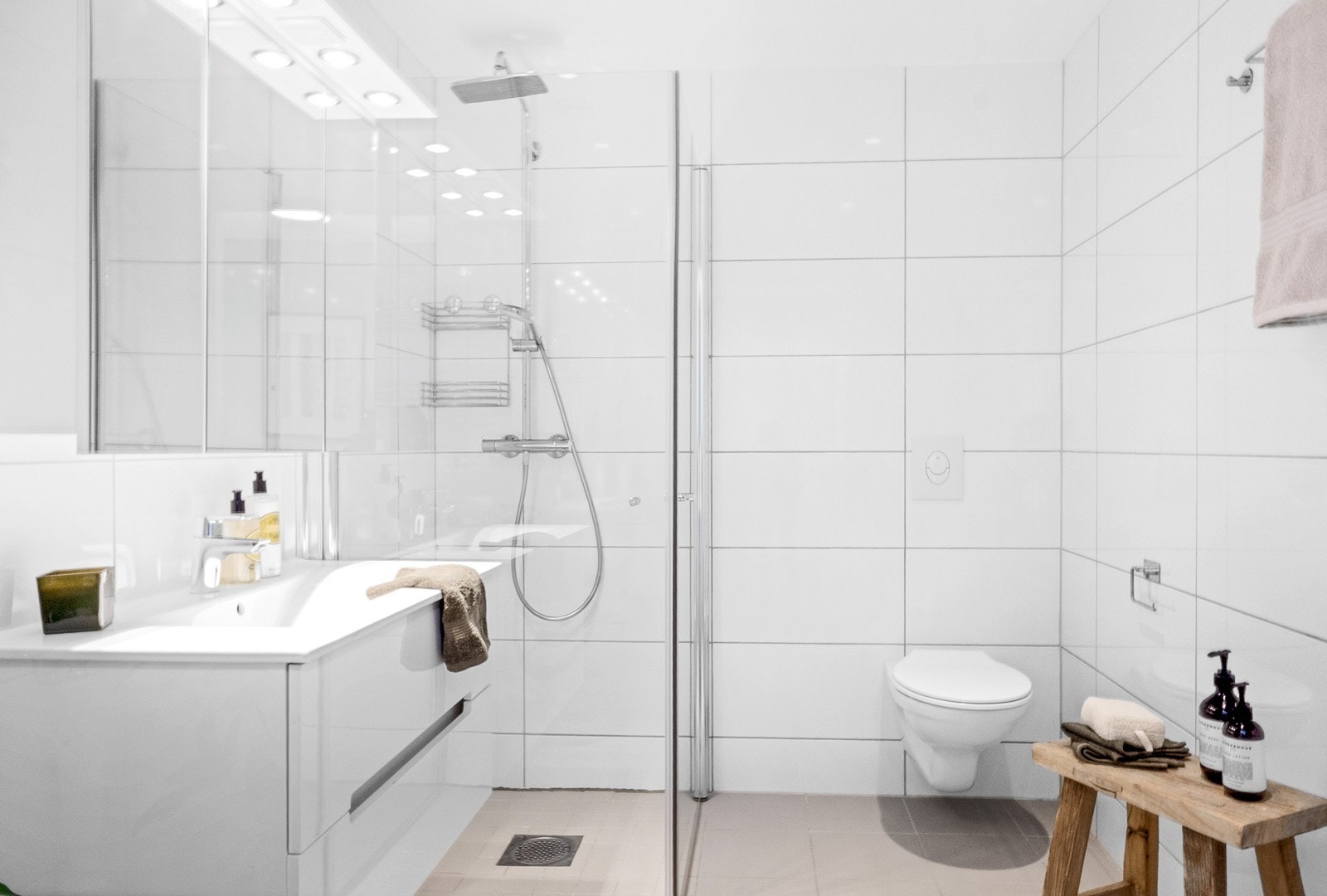 Det er dusjhjørne med innfellbare glassdører, veggmontert toalett, skuffeinnredning med nedfelt servant og speil med belysning. Her er også opplegg for vaskemaskin og tørketrommel. Galleribilde