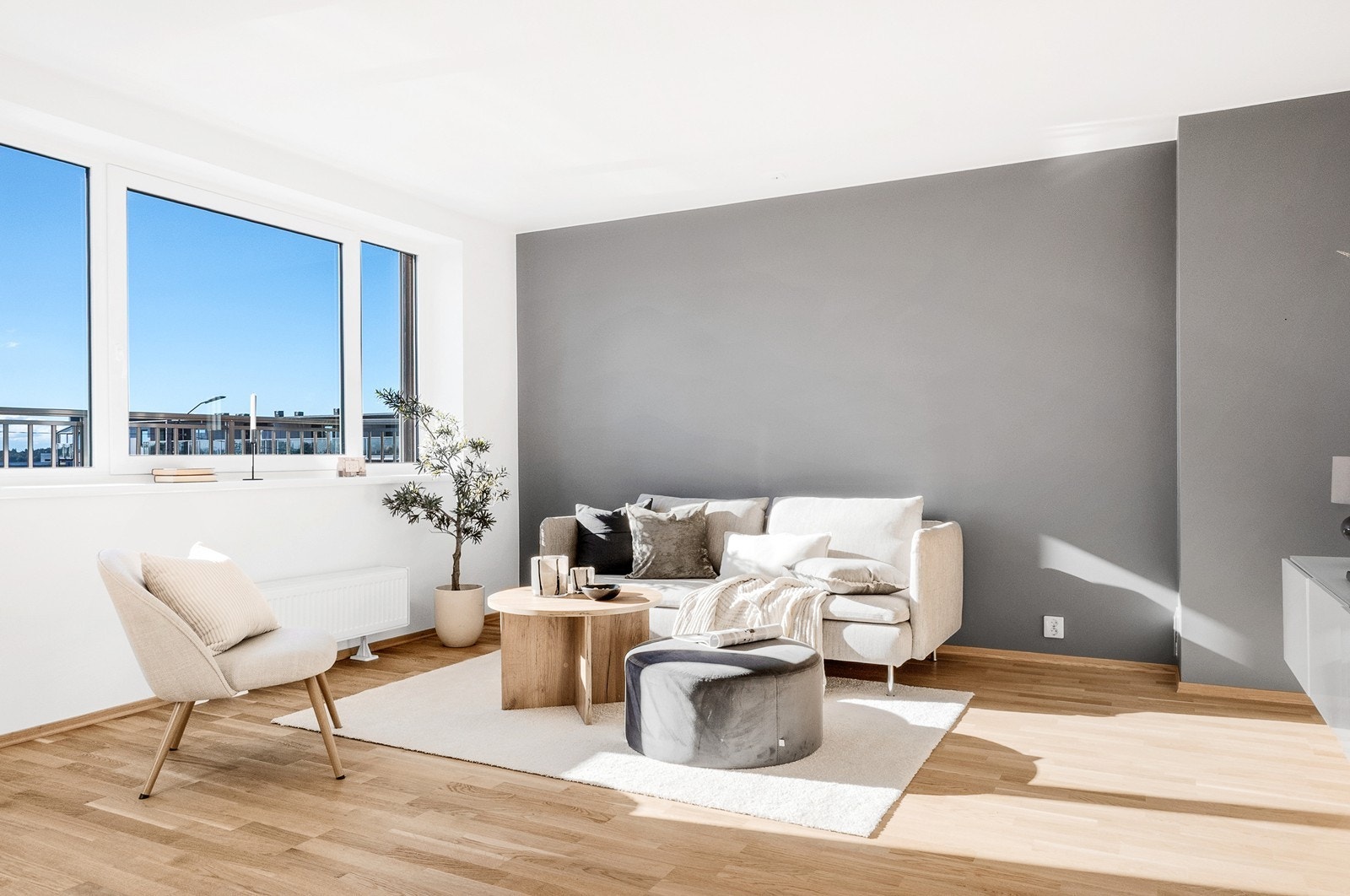 Stuen har en moderne stil med store vinduer som slipper inn rikelig dagslys og åpner rommet mot utsyn over nærområdet. Galleribilde