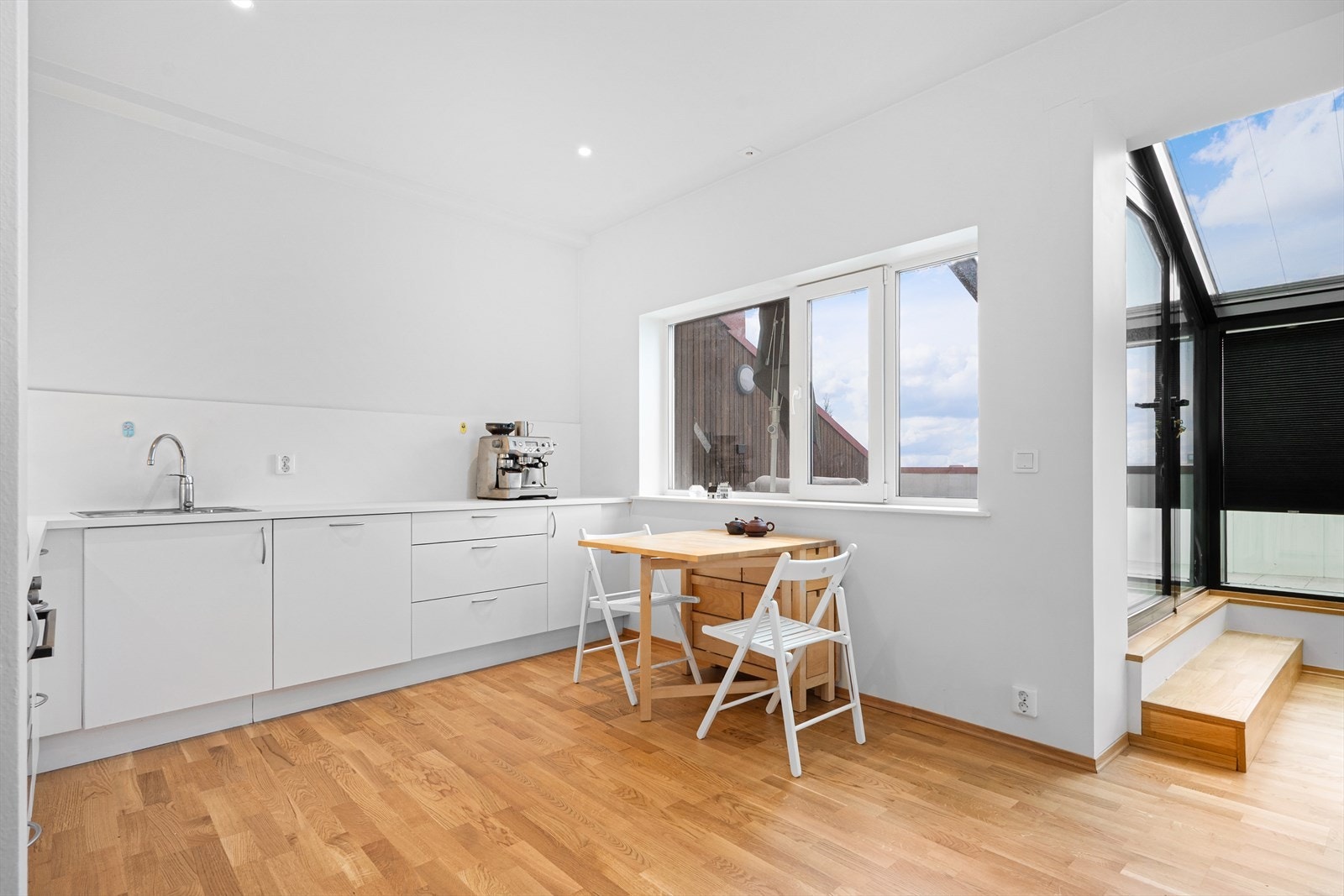 Ett trappetrinn leder opp til balkongen med sort aluminiumsramme. Galleribilde