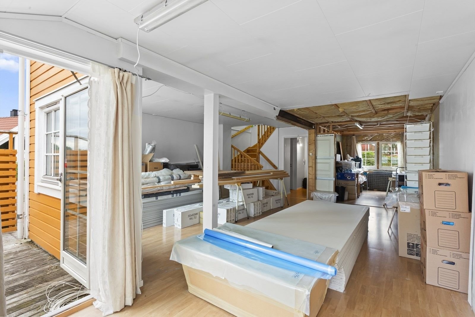 Stuen må pusses opp. Innerst til høyre vises kjøkken som er klargjort for oppussing. Man kan ha en vegg mellom kjøkken og stuen, eller ha en åpen kjøkken-/stueløsning. Se arbeidsbeskrivelse. Eier har kjøpt inn masse materialer for oppussing av boligen. Galleribilde