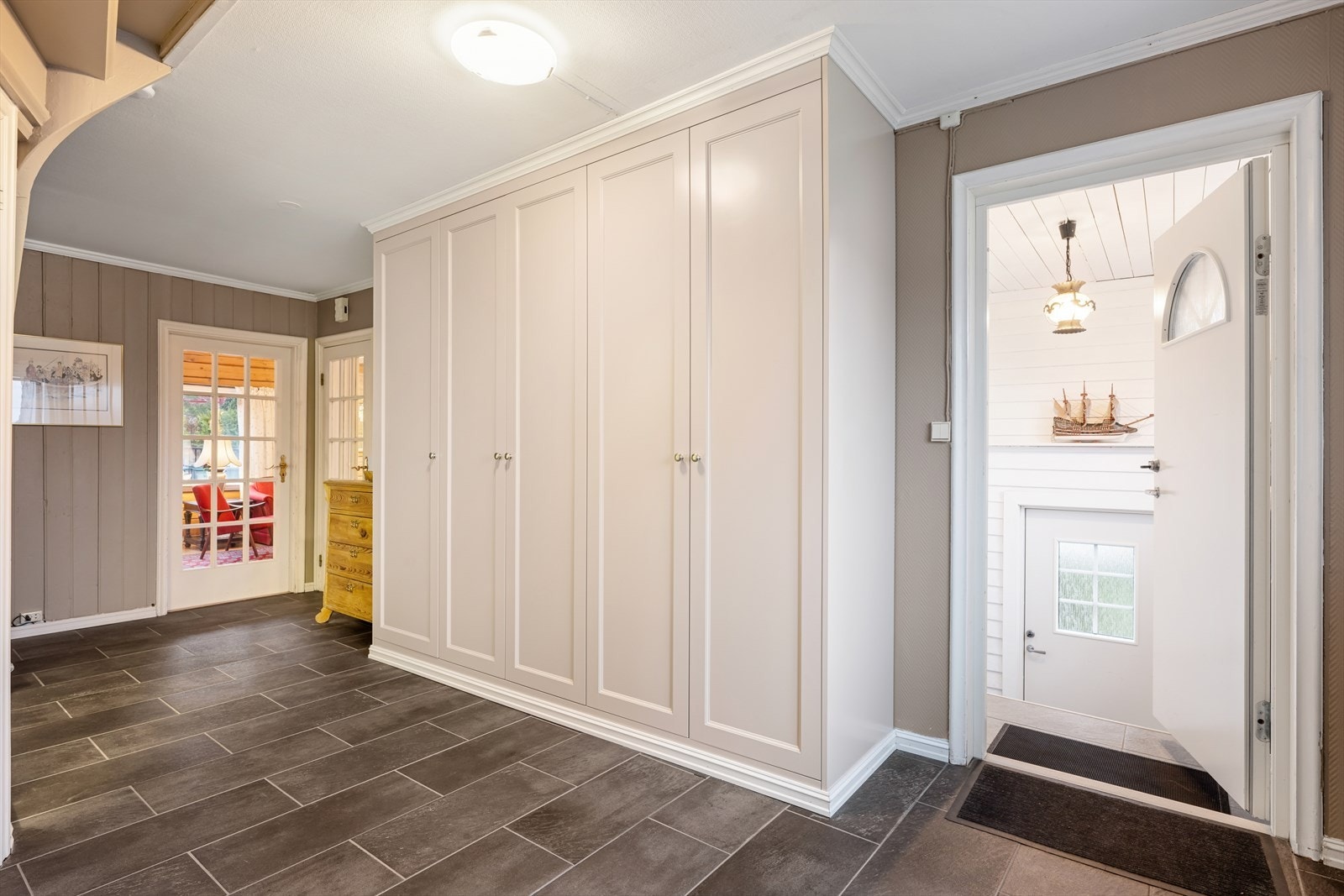 Romslig gang som er praktisk innredet med flislagt gulv og stor garderobe hvor man har god plass til å henge fra seg yttertøy og sko. Galleribilde