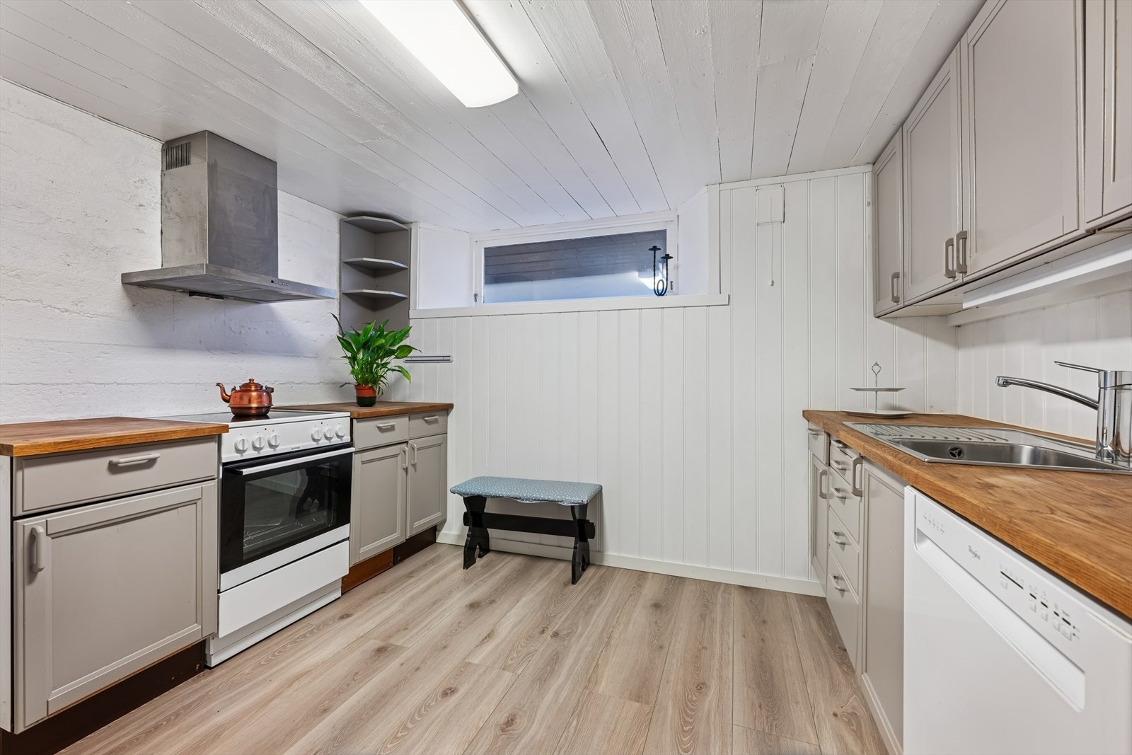 I kjelleretasjen finner man et kjøkken av eldre dato, men som ble montert i kjelleren i 2018. Kjøkkenet er innredet med profilerte, malte fronter og benkeplate av heltre. Også her har man godt med skap- og skuffeplass, samt gode arbeidsflater på benk. Galleribilde