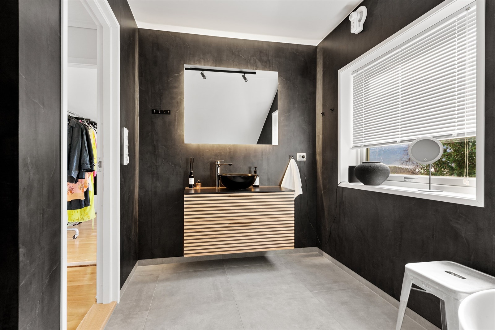 Flott baderomsinnredning med skuffer og ovenpåliggende servant. Speil med side/overlys over servant Galleribilde